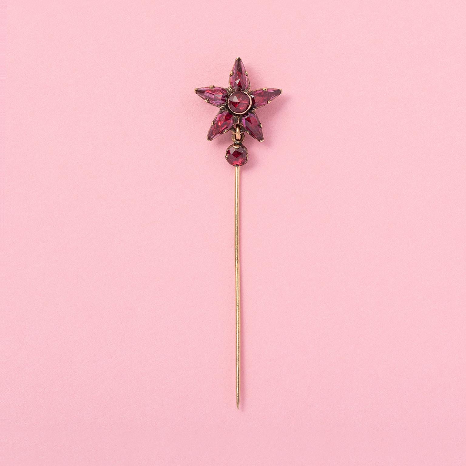 An 18 carat gold stick pin with a star and drop of rose cut rhodolite garnets set on red gold foil, South of France circa 1880.

weight: 2.03 grams
dimensions: 6.5 x 1.6 cm