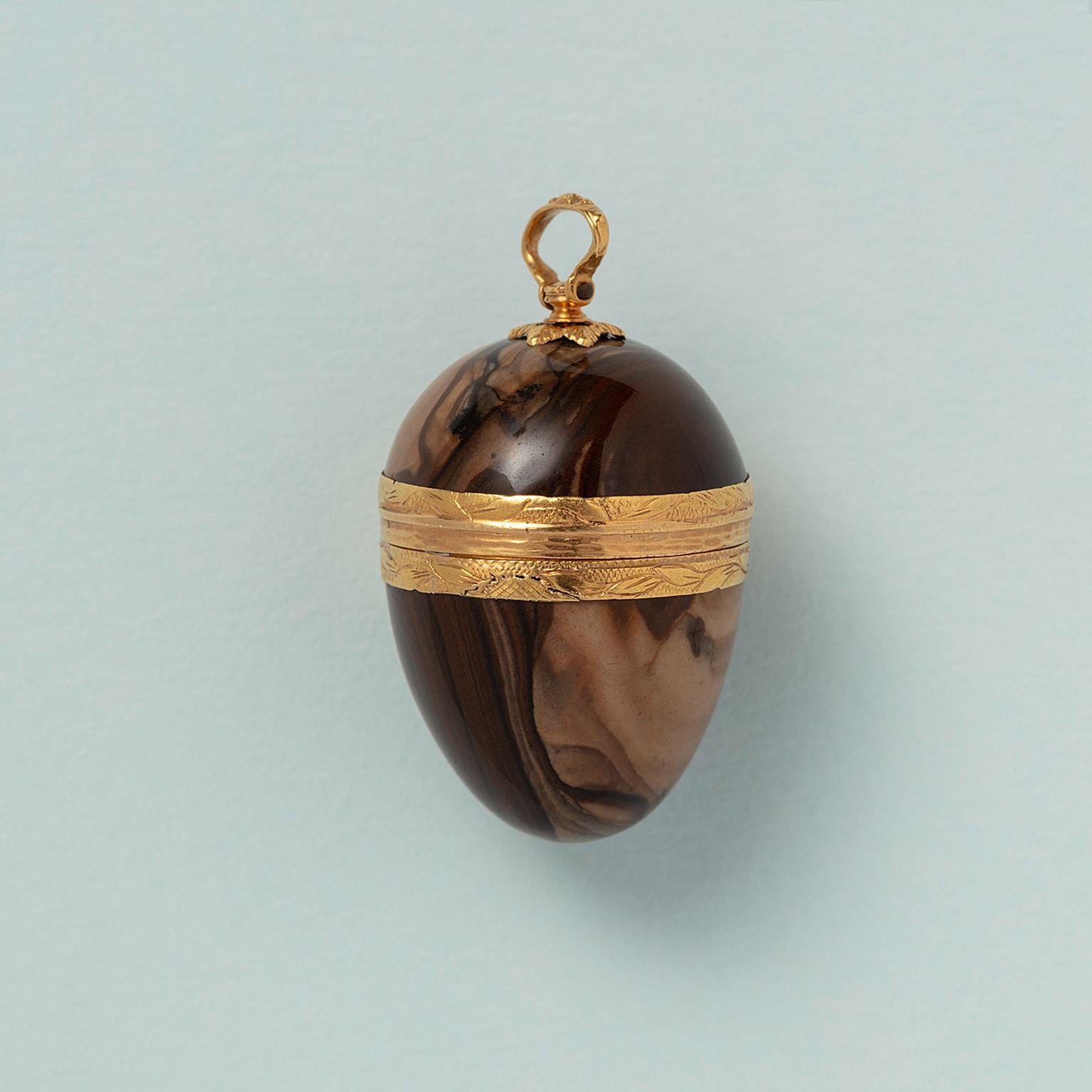An 18 carat and jaspis egg box pendant with 18 carat gold mounting, the edges around and the hinge with which the box opens are engraved with leaves, France, 18th century.   

weight: 7.55 grams
dimensions: 1.8 cm x 2.5 cm