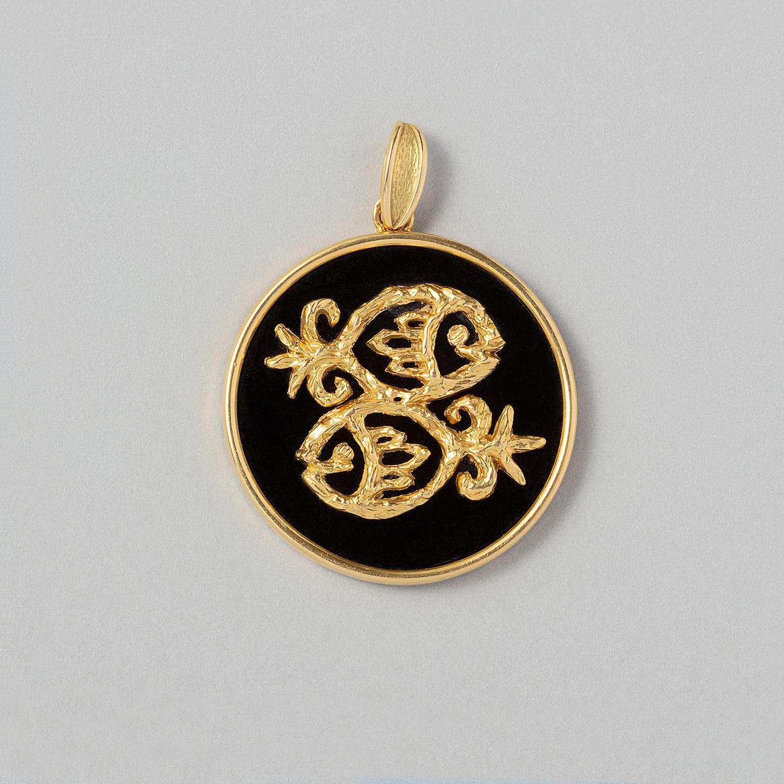A round 18 carat yellow gold pendant set with an onyx plaque and a pisces zodiac made of textured gold. France, circa 1970.

weight: 15.04 gram
dimensions: 5 x 3.7 cm