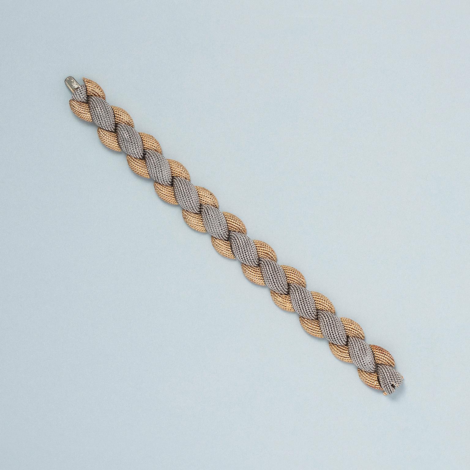 An elegant 18 carat yellow and white gold and platinum textured bracelet with a invisible lock. signed and numbered: Sterlé, Paris, 2.934. France, circa 1960.

weight: 68.73 g
length: 17.5 x 1.5 cm. for a small to medium wrist
