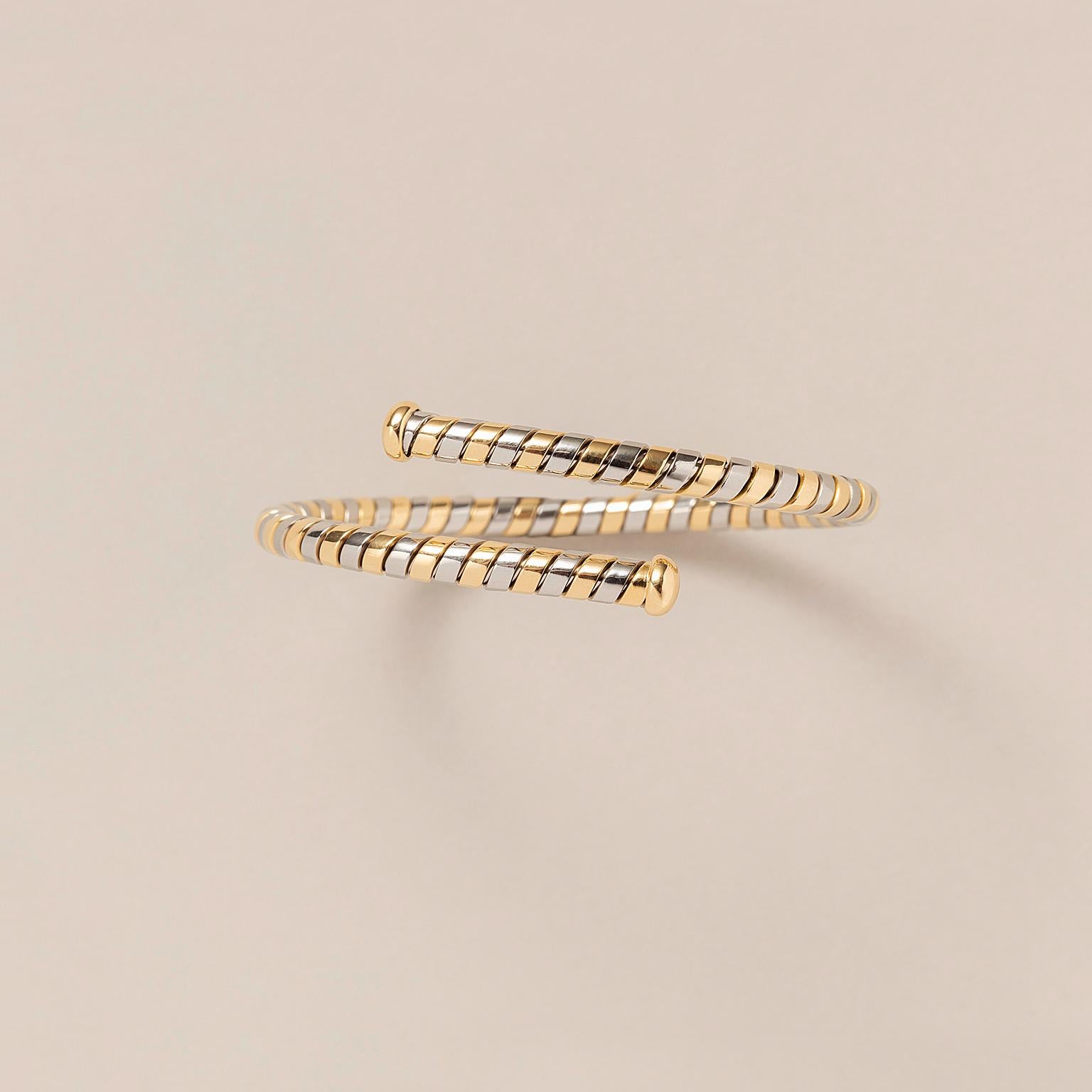 Manschettenarmreif aus nebeneinanderliegenden, gedrehten Bändern aus grauem Stahl und 18 Karat Gold mit goldenen Enden, signiert: Bulgari, um 1980.

Gewicht: 20,34 g
Größe: für ein kleines bis mittleres Handgelenk
Breite: 4,5 - 15 mm