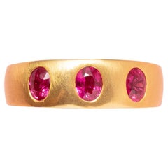 An 18 Carat Gold Band Three Stone Ring with Rubies