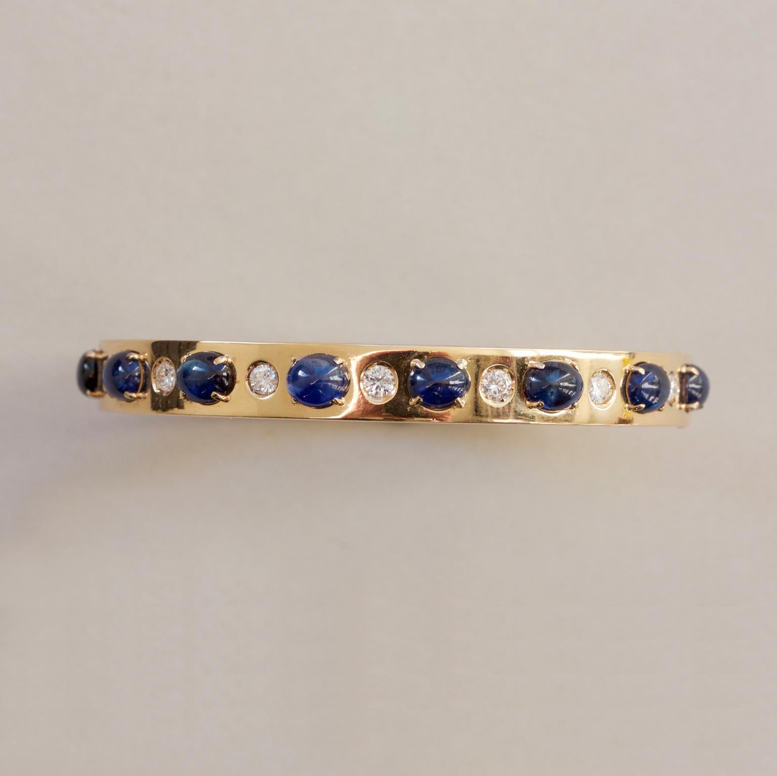 An 18 carat gold bangle set with eight oval cabochon cut sapphires (app. 7 carats), horizontally set in between which are seven brilliant cut diamonds (app. 0.42 carat), Italy, circa 1980.

circumference: 17-17.5 cm fits a 16-17 cm wrist
weight: