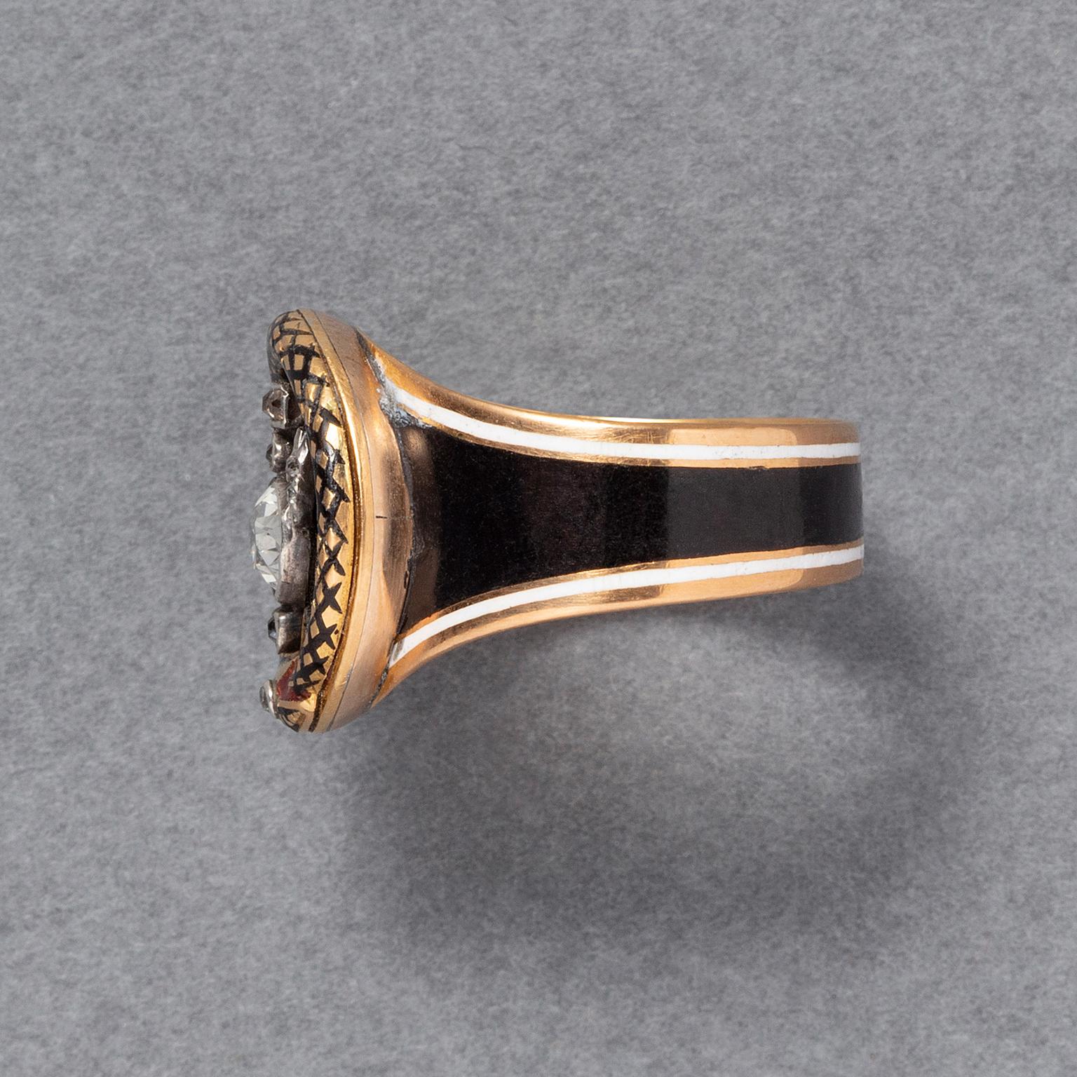 An 18-carat yellow gold mourning ring featuring a diamond urn with an oval cushion-cut diamond. Surrounding the urn is an ouroboros, a snake devouring its own tail, embellished with crosshatched black enamel. The shank is also decorated with black