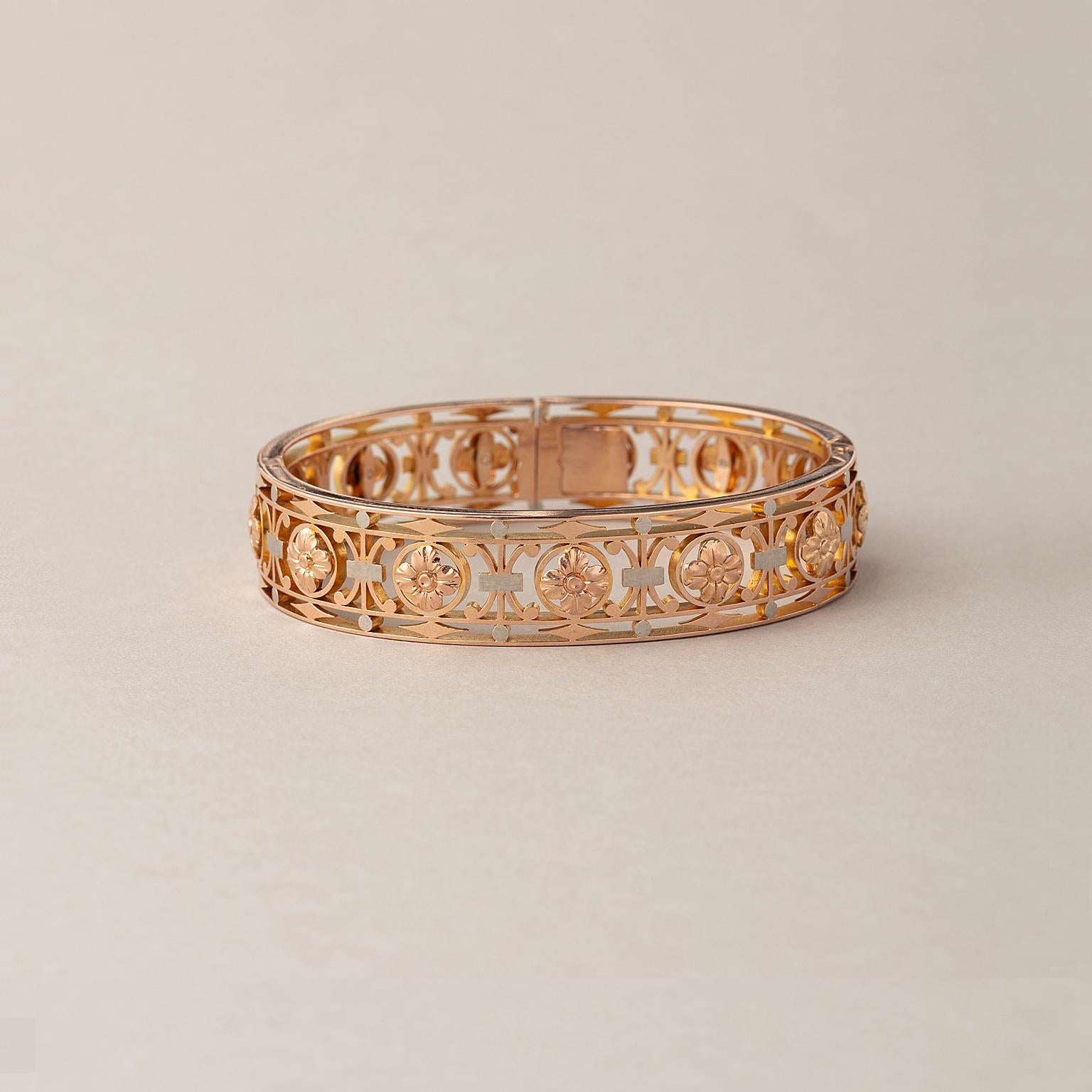 An 18 carat gold bangle with invisible lock opening with two hinges at the back with the decor of a fence with rosettes, kites and scrolls, France, end 19th century.

weight: 38.8 gram
fits a regular wrist