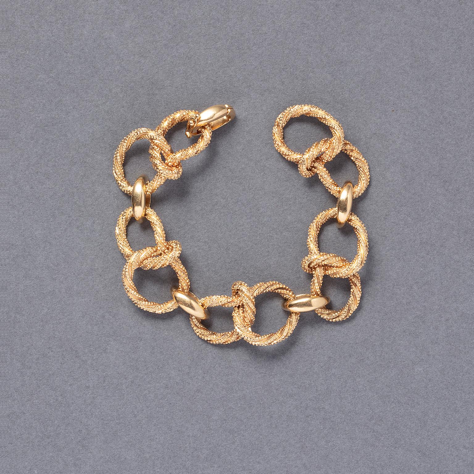 Un bracelet en or 18 carats avec des maillons en corde torsadée, alternés avec des maillons courbés polis, et un fermoir invisible avec rabat de sécurité, avec des marques d'essai françaises pour l'or 18 carats et la marque de maître française pour