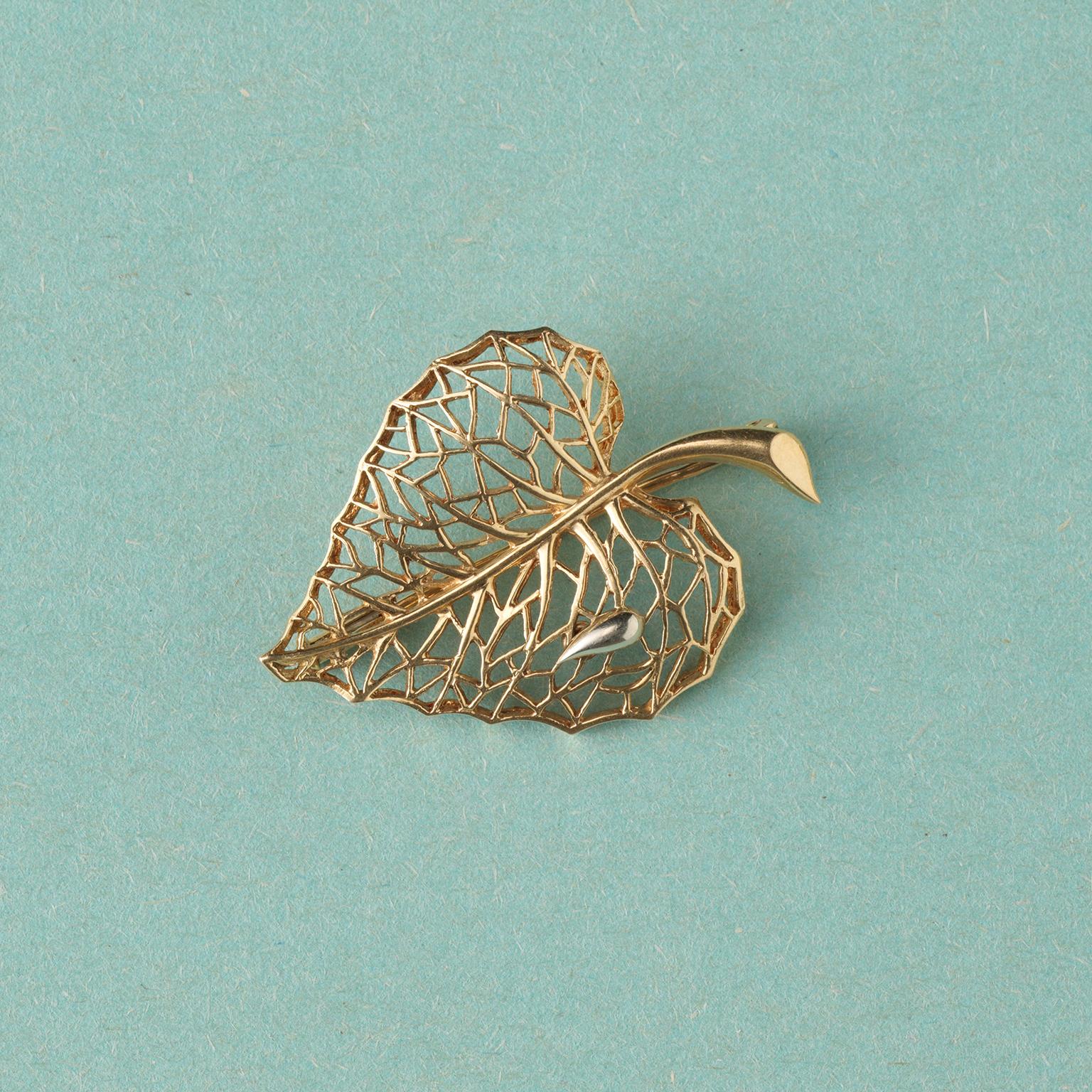 An 18 carat gold leaf brooch open worked with a drop of dew, France.

weight: 6.76 grams
dimensions: 4 x 2.8 grams