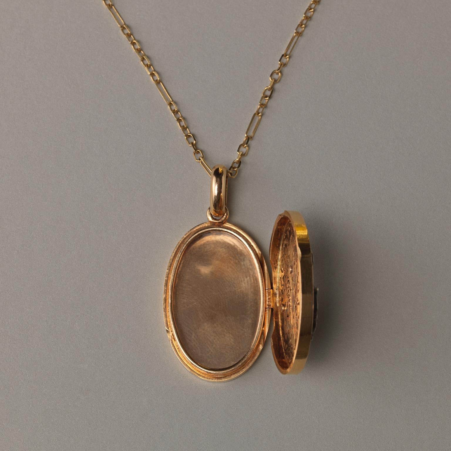 An 18 carat gold oval locket open worked with scrolls with an ornamental initial A set with rose cut diamonds and one locket compartment, the back is engraved with the initials AI or AJ, French 19th century.

weight: 19.84 grams
dimensions: 4.5 x
