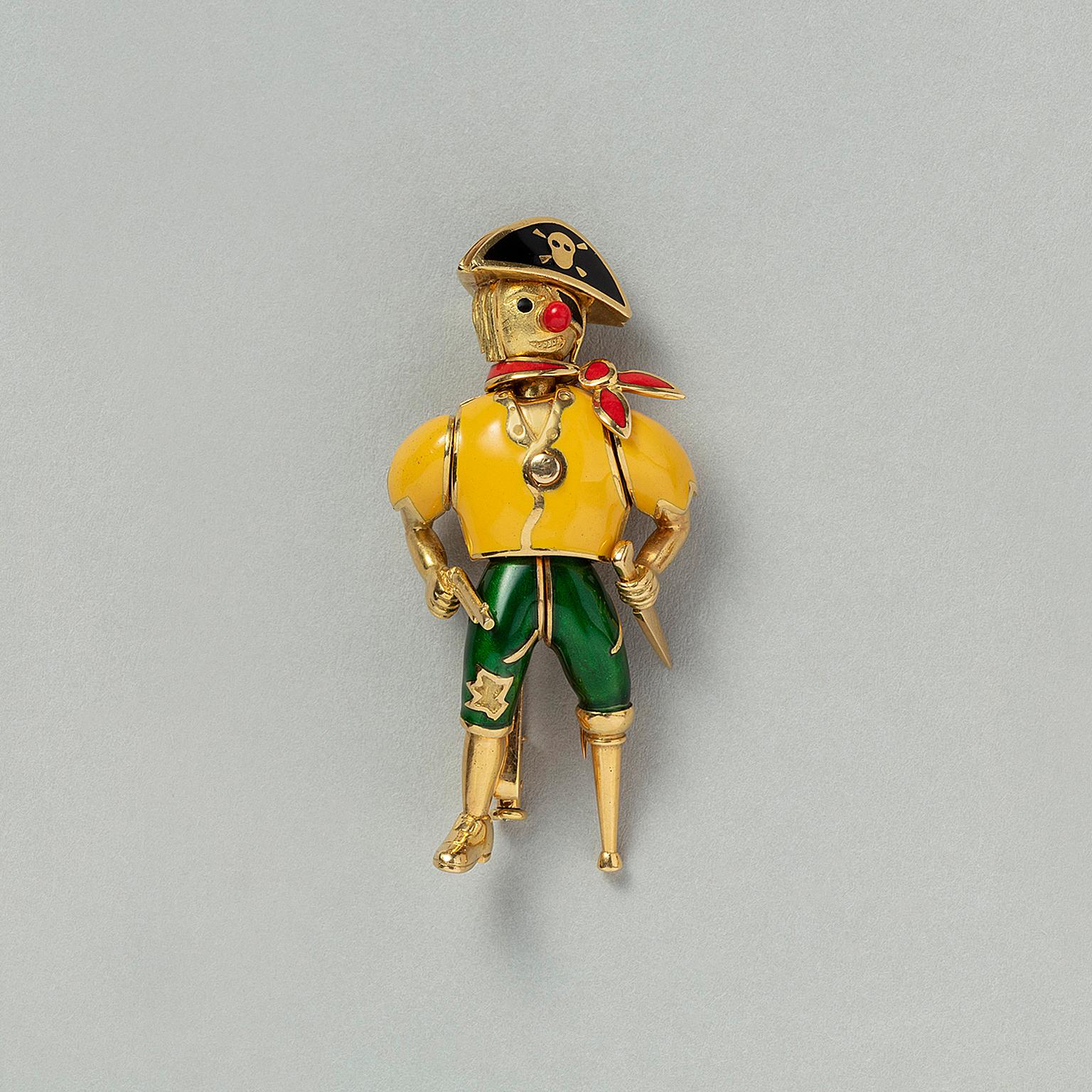 An articulate 18 carat yellow gold brooch of a pirate with a yellow enamel shirt, green trousers a red scarf and a black stitch with a skull, he is carrying a gun and a knife and has a wooden leg, France, circa 1970.

weight: 23.55 grams
dimensions: