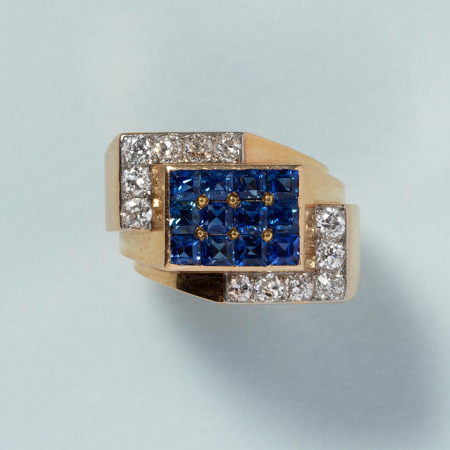 An 18 carat yellow gold retro tank ring pavé set with twelve carré cut sapphires (app. 1.44 carat in total) in a rectangle in the middle hold by two L-shapes each set with six old cut diamonds (app. 0.84 carat in total). France, 1930.

weight: 10.08