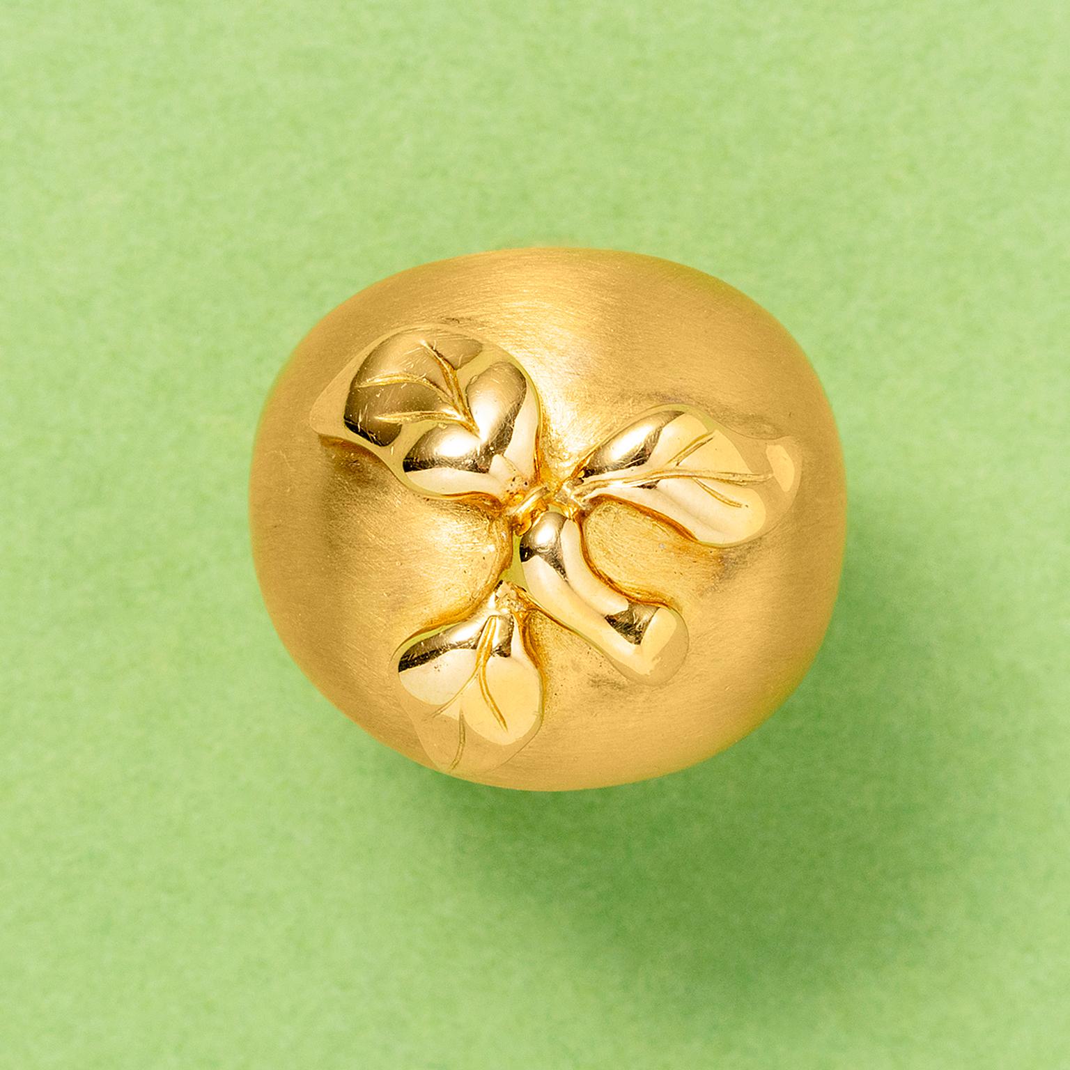 An 18 carat gold ring in the shape of an apple, with a matte surface and with polished leaves and stem, France with aFrench assay mark and French master mark.

weight: 14.6 g
ring size: 15.75 mm / 5 US fits as a 16 - 16+ mm / 5.5 US