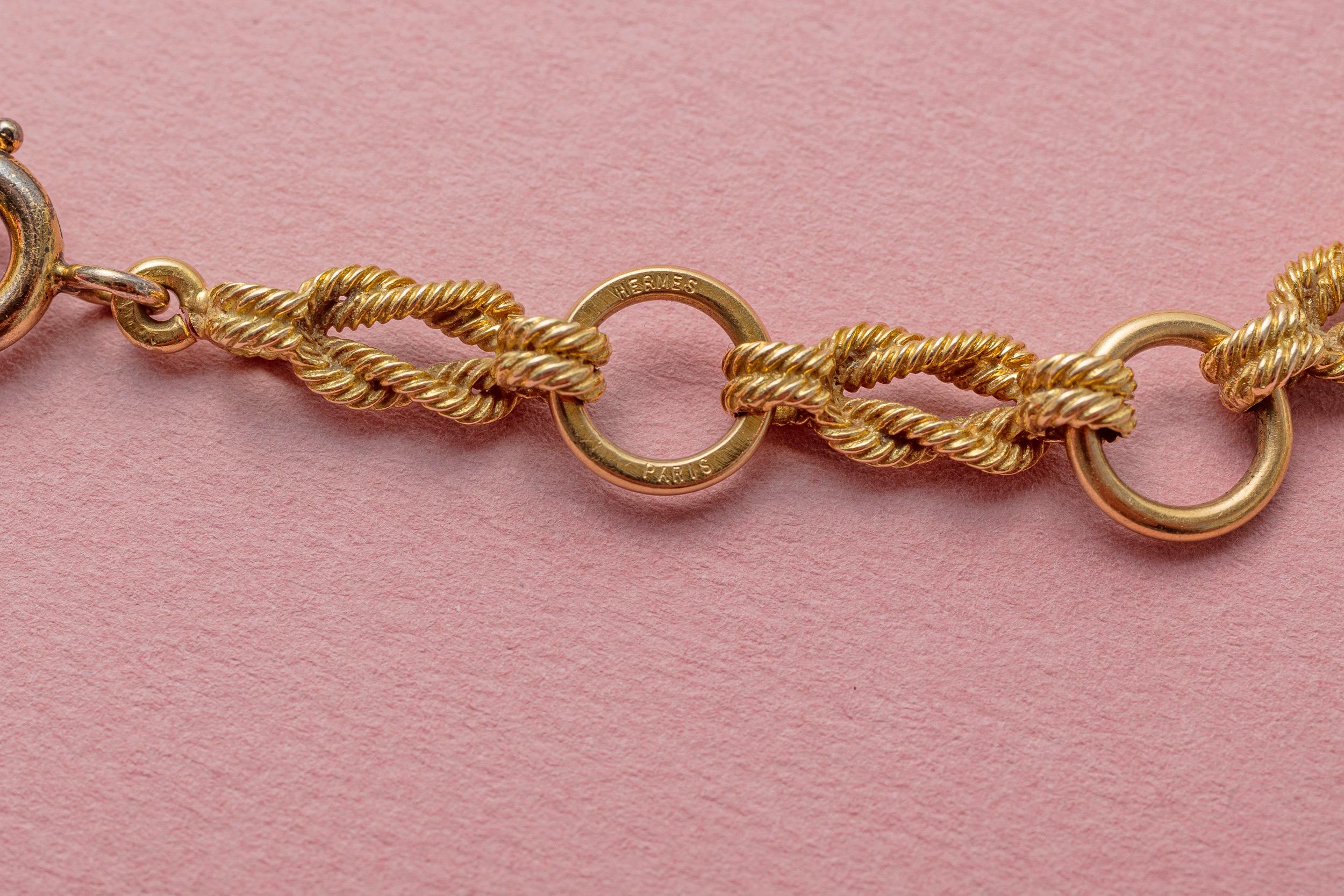 An 18 carat yellow gold necklace with links of flat knots tied with gold ropes alternated by round links, French mastermark: for Pierre Lefebvre, signed and numbered: Hermès Paris, French, circa 1970.

weight: 38.78 grams
length: 42 cm