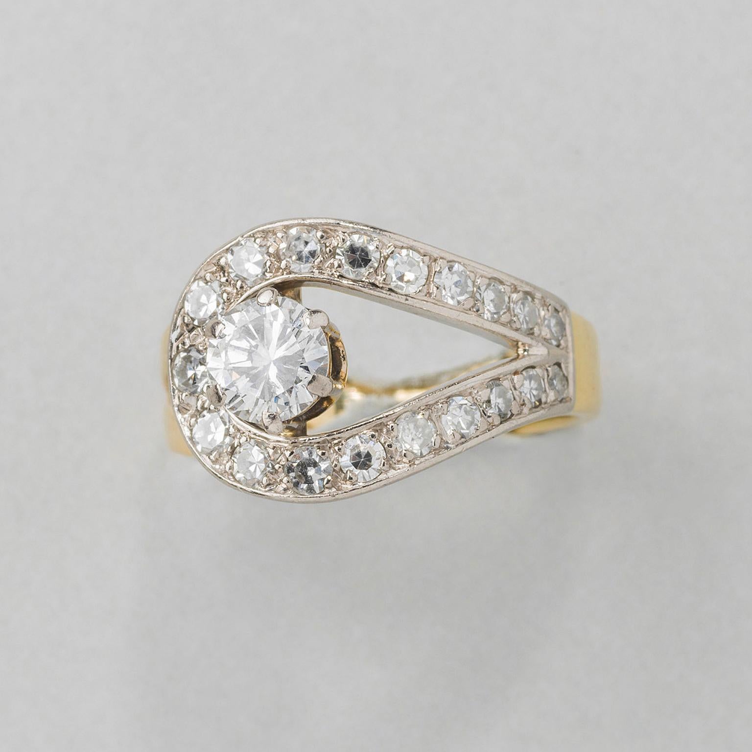 An 18 carat yellow gold ring with a white gold loop set with 19 diamonds (app. 0.76 carat) set in the center with a brilliant cut diamonds (app. 0.53 carat, ans app. 1.29 carat in total).

weight: 6.7 grams
ring size: 16.25 mm / 5.5 US
width: 3 – 12