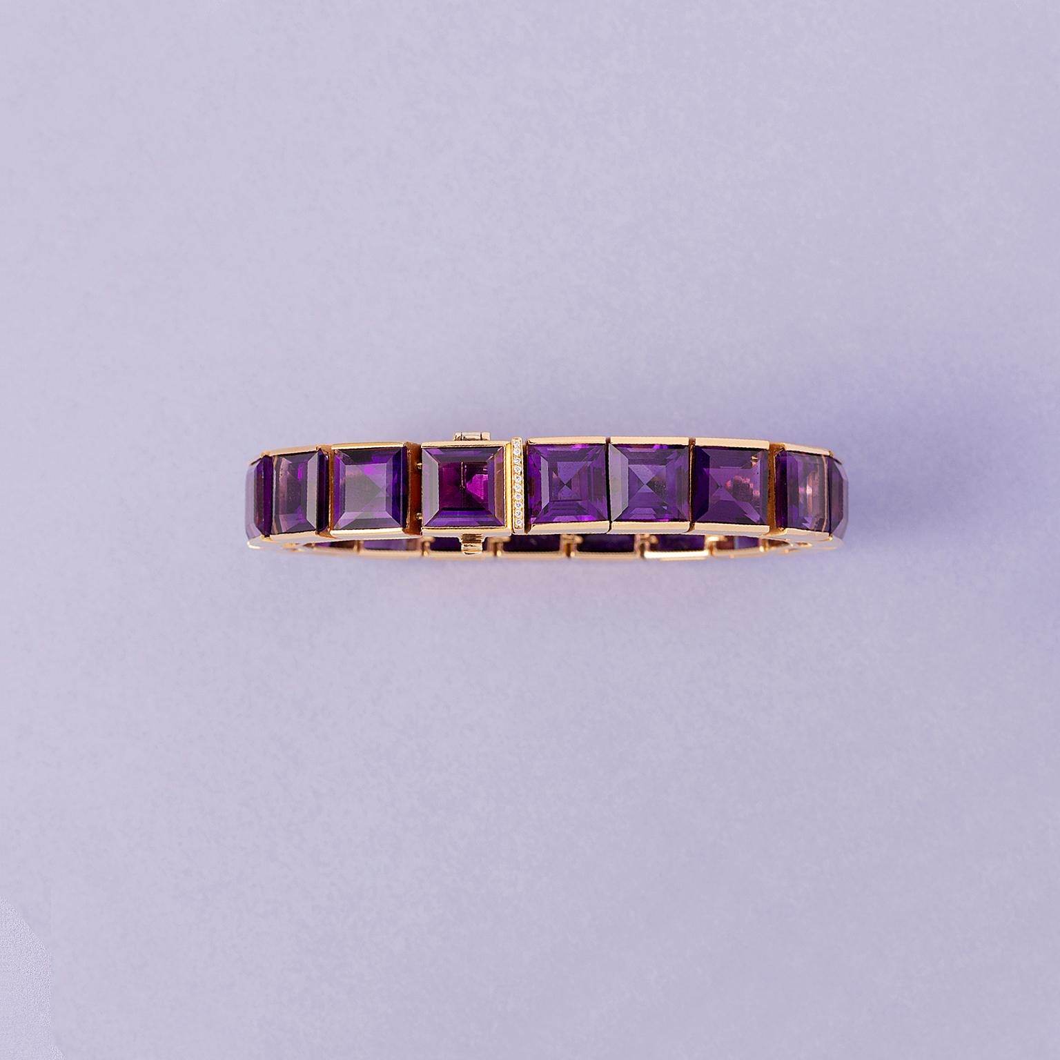 An 18 carat yellow gold line  bracelet set with eighteen carré cut amethysts set in a line in flexible links. An invible lock with a row of ten brilliant cut diamonds set in a vertical row on the push-button to open the bracelet, signed: Peter Pütz,