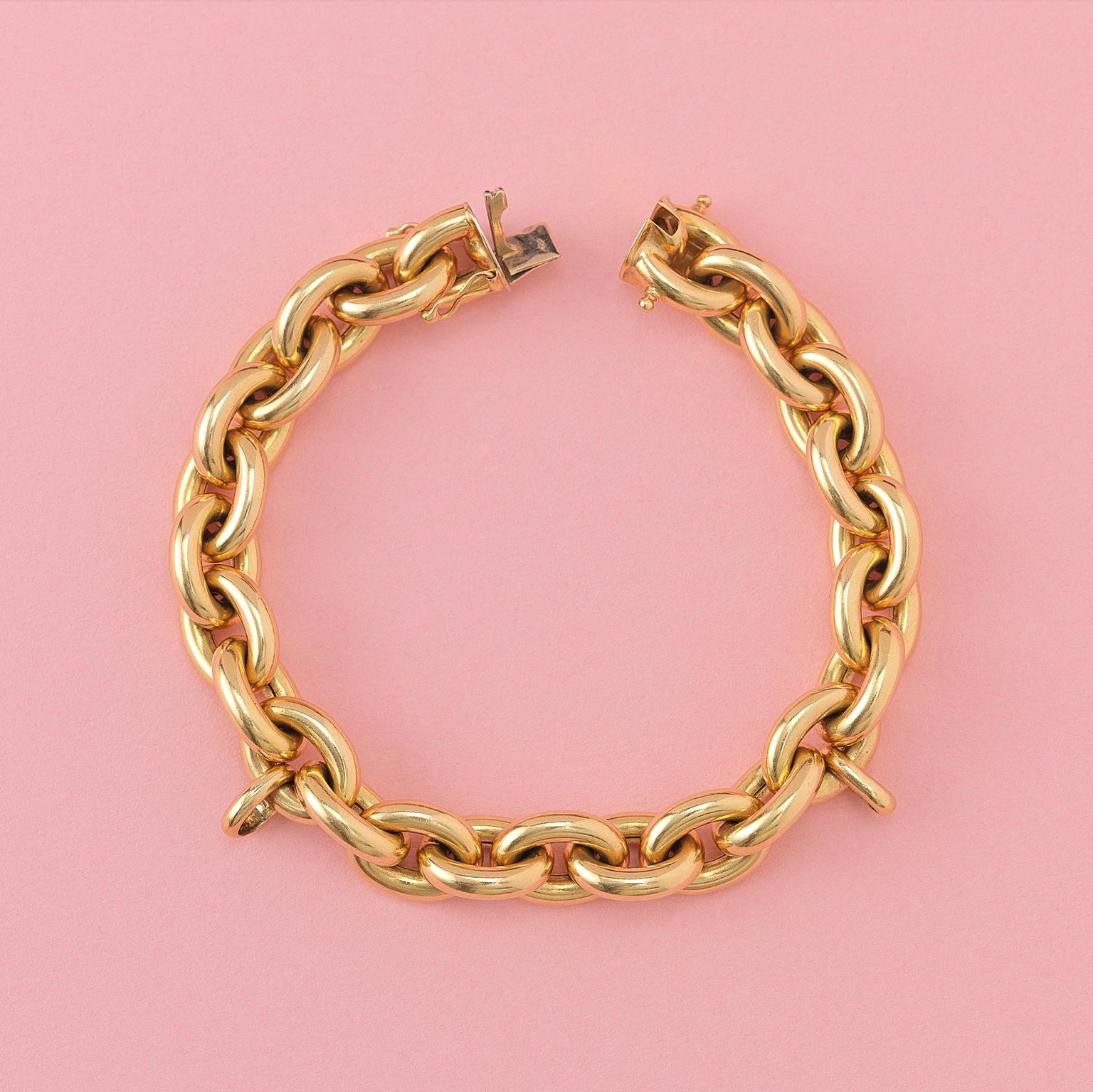An 18 carat gold link bracelet with two large links for charms and a hidden lock, France circa 1980.

weight: 50.87 grams
length 21 cm.
width: 12 mm.