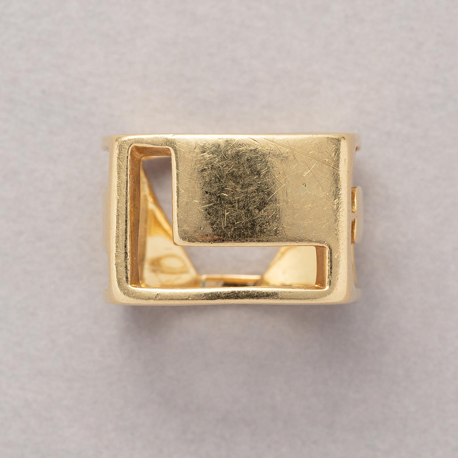 A rectangular, 18 carat yellow gold ‘Love’ band ring made of cut-out letters ‘L’, ‘O’, ‘V’ and ‘E’. Signed Tiffany, attributed to Donald Claflin for Tiffany & Co. End of 1960-1970.

weight: 12.64 grams
size: 18.5 mm / 7 1/2 US
width: 12.5 mm / 1/2