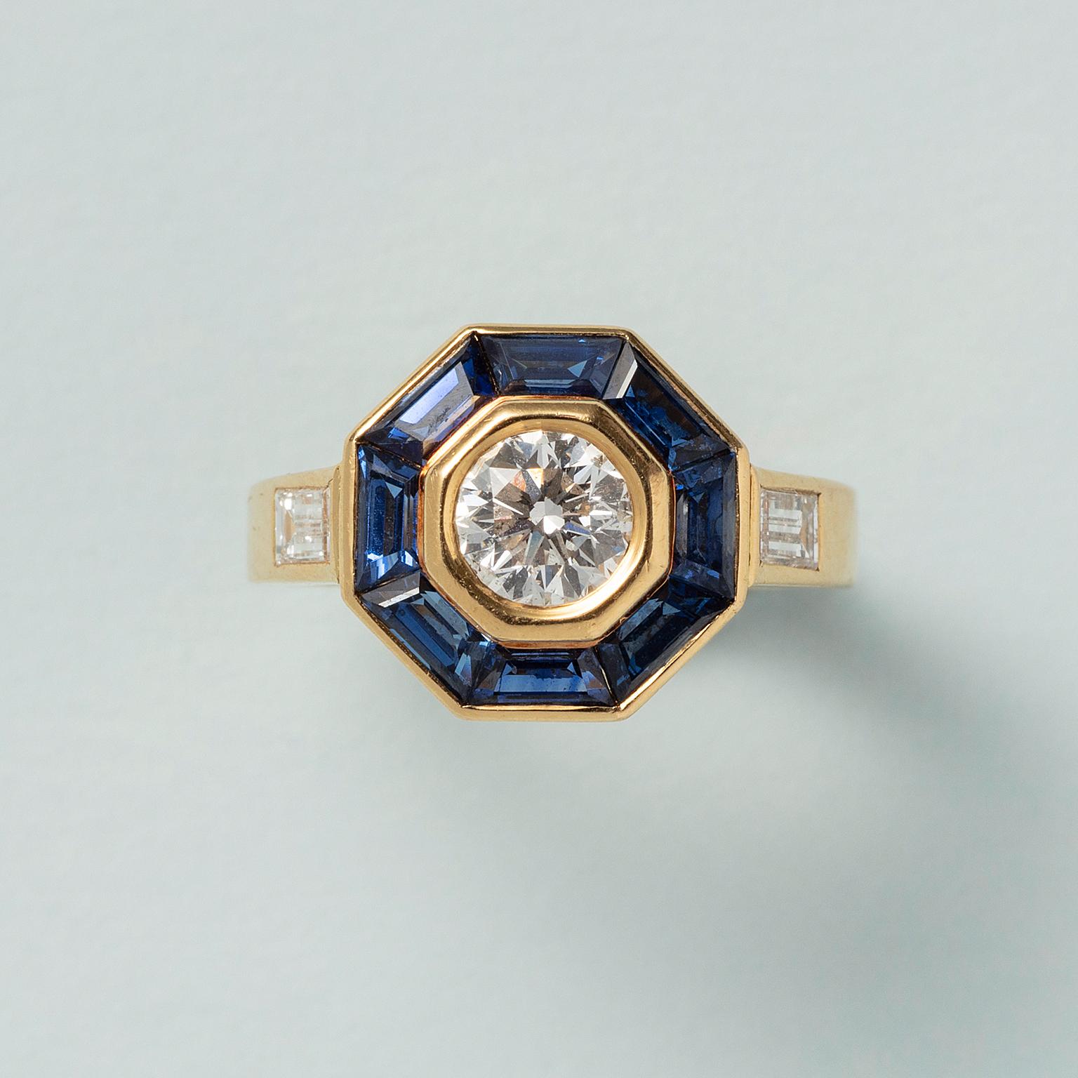 An 18 carat yellow gold ring with an old brilliant cut diamond (0.5 ct, GH-I), with a halo of eight trapezium cut sapphires, signed and numbered: Mellerio, 35357, France.

weight: 4.9 g
size: 15.25 / 4.5 US
dimensions halo: 10 x 10 mm
width shank: 2