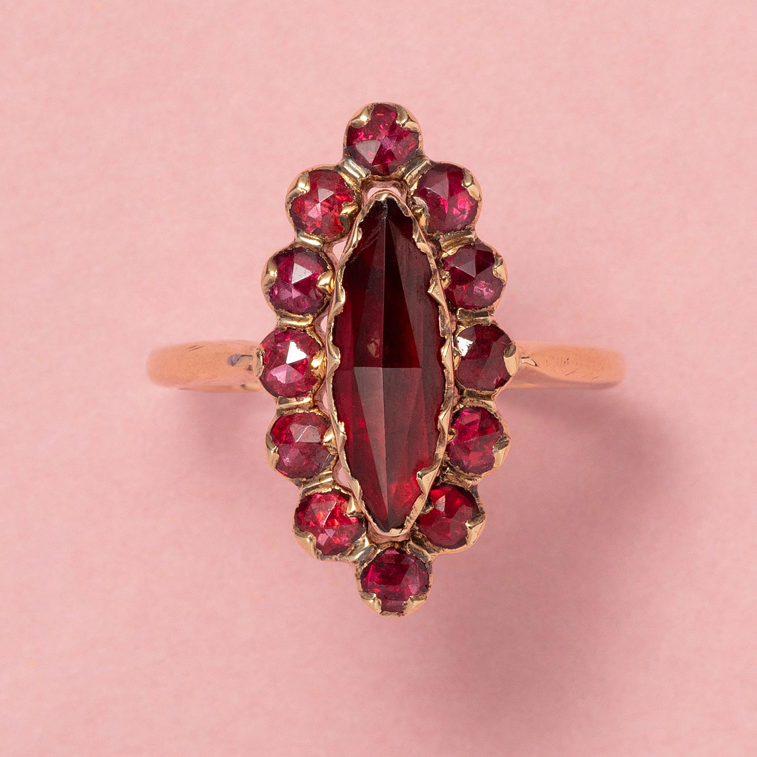 An 18 carat gold navette shaped ring set with rose cut rhodolite garnets on red gold foil, South of France, Perpignan region, early 20st century.

weight: 3.8 grams
dimensions: 2.2 x 1.1 cm
ring size: 18 mm / 8 US