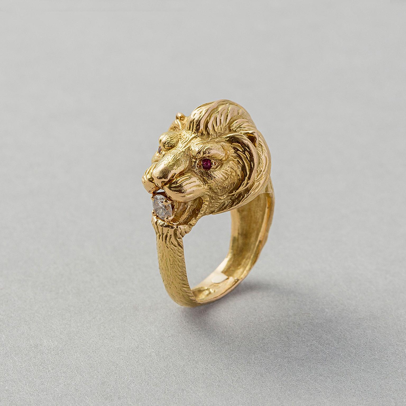 An 18 carat gold ring representing a lions head with textured fur all around the shank with ruby eyes and in its mouth a brilliant cut diamond (app. 0.1), France, circa 1970.

ring size: 15.25 mm / 4.5 US
weight: 11.8 grams