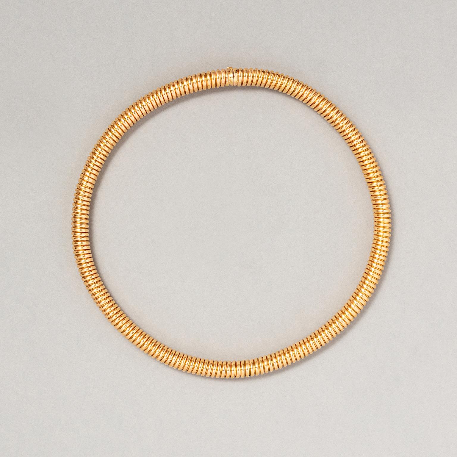 An 18 carat yellow gold tubogas necklace with a box lock and a safety eight clasp, master mark: Weingrill, circa 1960.

The tubogas, or gas pipe, was popularised in the 1930s due to the scarcity of resources during World War II. Gas-pipe jewellery