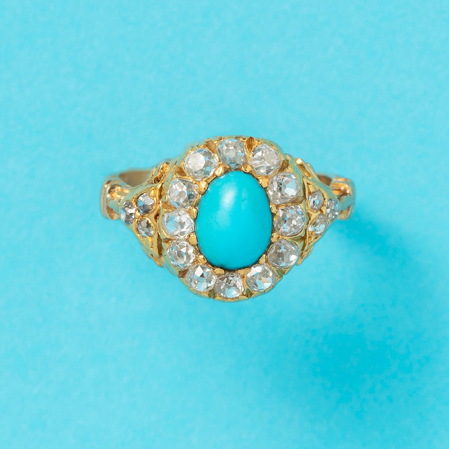 An antique, 18 carat yellow gold cluster ring set with an oval, cabochon cut turquoise surrounded with twelve old cut diamonds and with three old cuts on each side in the shank (in total app. 1.4 carat), most likely English in origin, end 19th