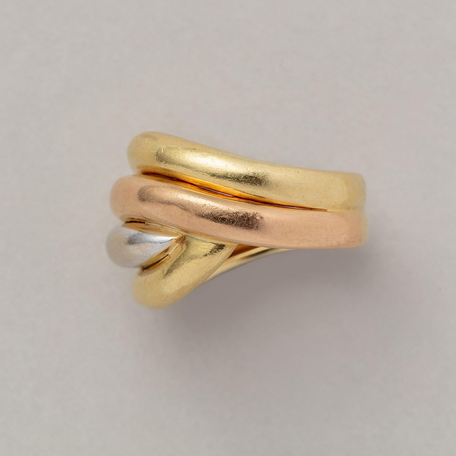An 18 carat tri-color gold knot ring, from top to bottom: yellow,white, rose yellow, signed: Fred, Paris
weight: 9.62 grams. 
ring size: 18 mm. / 7.75 US.
width: 0.7-1.7 cm