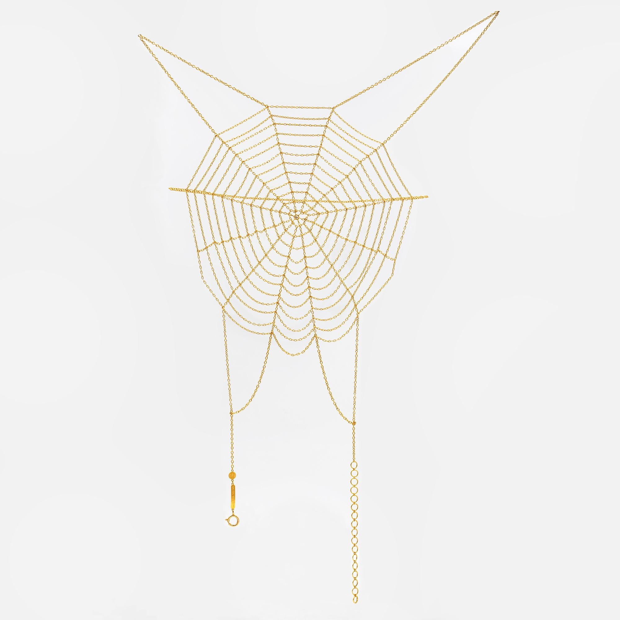 An 18 carat yellow gold spiders web anklet foot adornment by Lucie Heskett Brem set to the centre with a small round brilliant-cut diamond, bearing the Swiss convention mark for 18 carat gold, measuring approximately 26x19cm,  gross weight 11.23