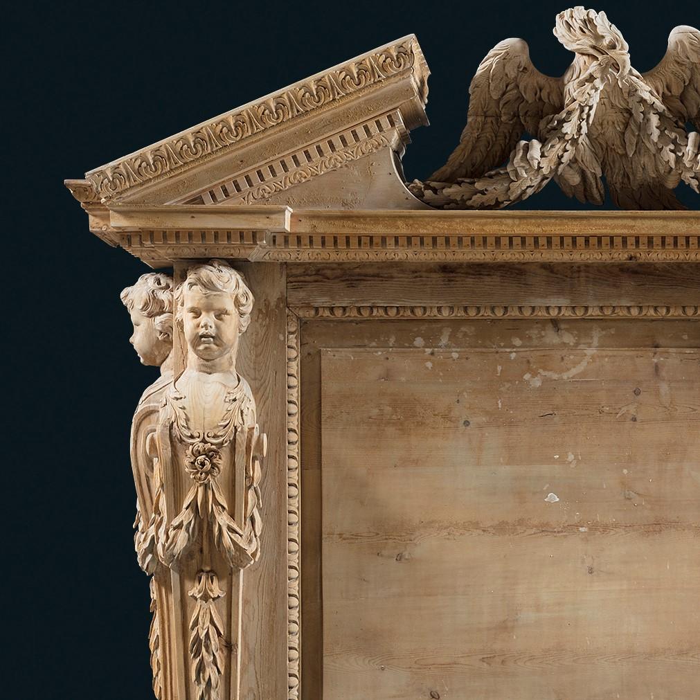 An extremely fine mid-18th century Palladian overmantle chimneypiece in carved pine in the manner of Inigo Jones. The overmantle section is crowned by a broken pedimented shelf centred by a richly carved Imperial Roman eagle, clasping festoons of
