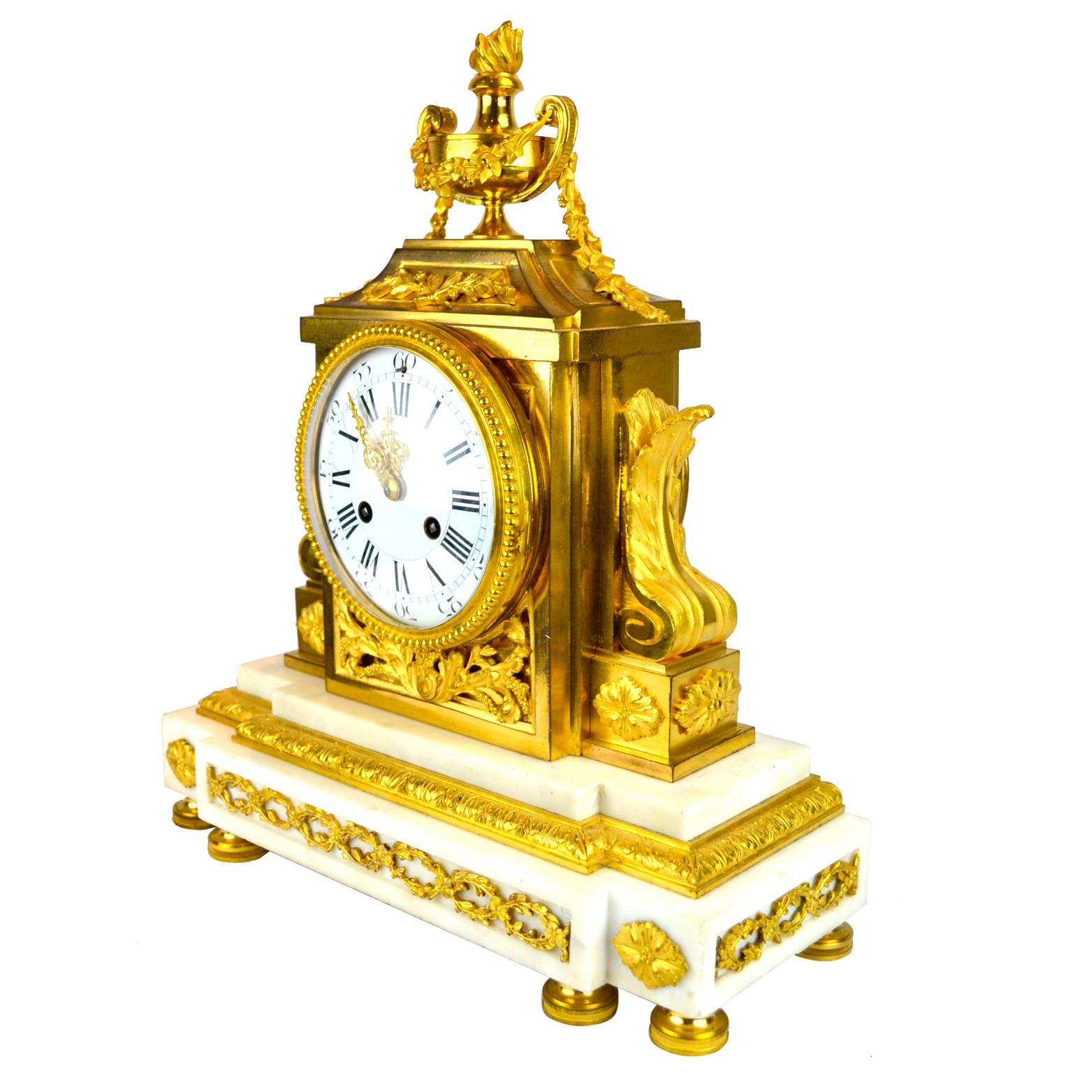 A very finely cast Louis XVI style marble and gilt bronze clock of architectural form. The rectangular stepped white marble bases sitting on six toupie feet, the lower front frieze decorated with paterae and entwined gilded floral vines. The white
