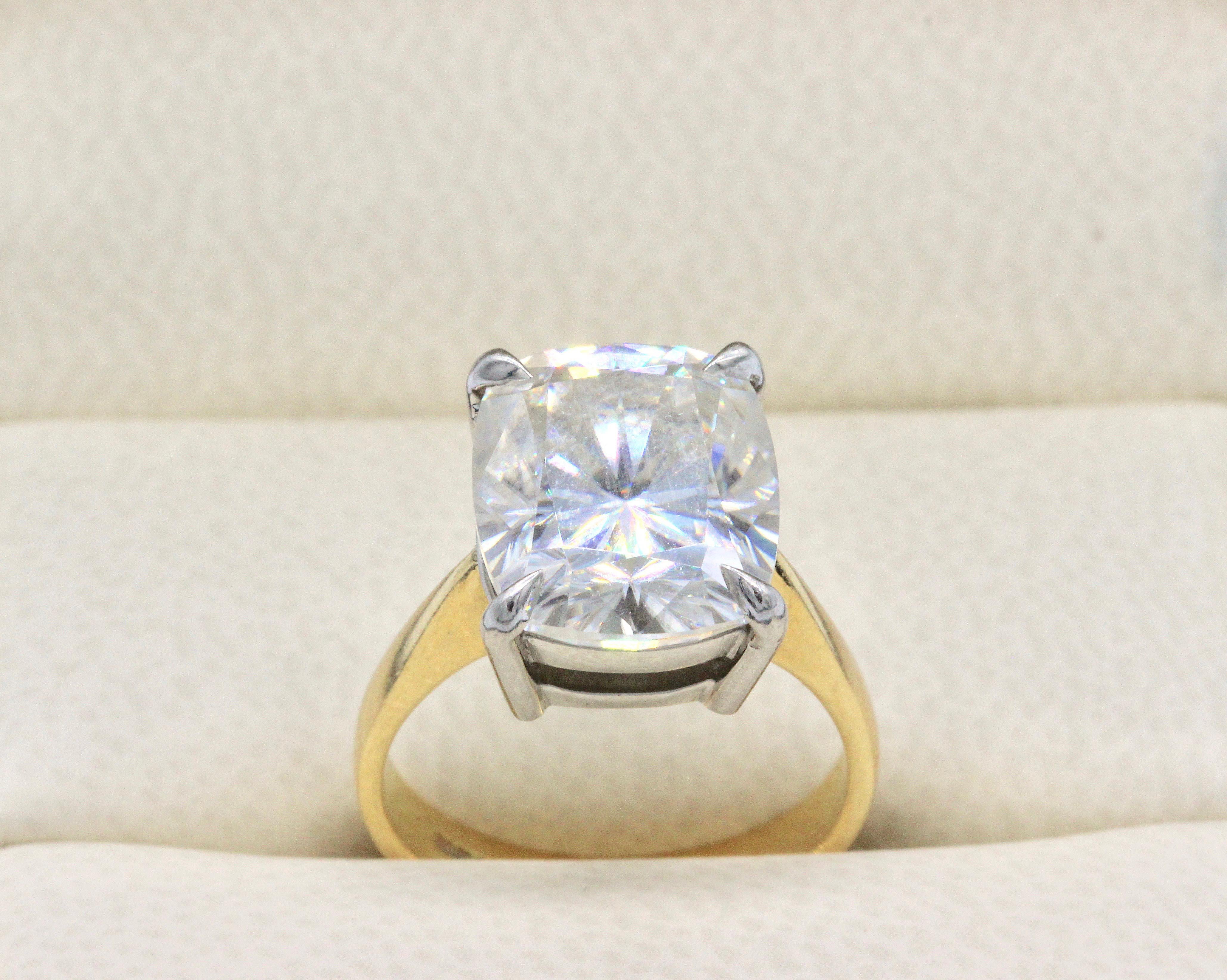 An 18 Karat Yellow Gold and Platinum set 6.25 carat cushion cut Moissanite Solitaire Ring.
Hallmarked Birmingham UK  750
Moissanite measuring 12.10 x 10.01 x 7.62 mm.
Anchor certificate number 20049140