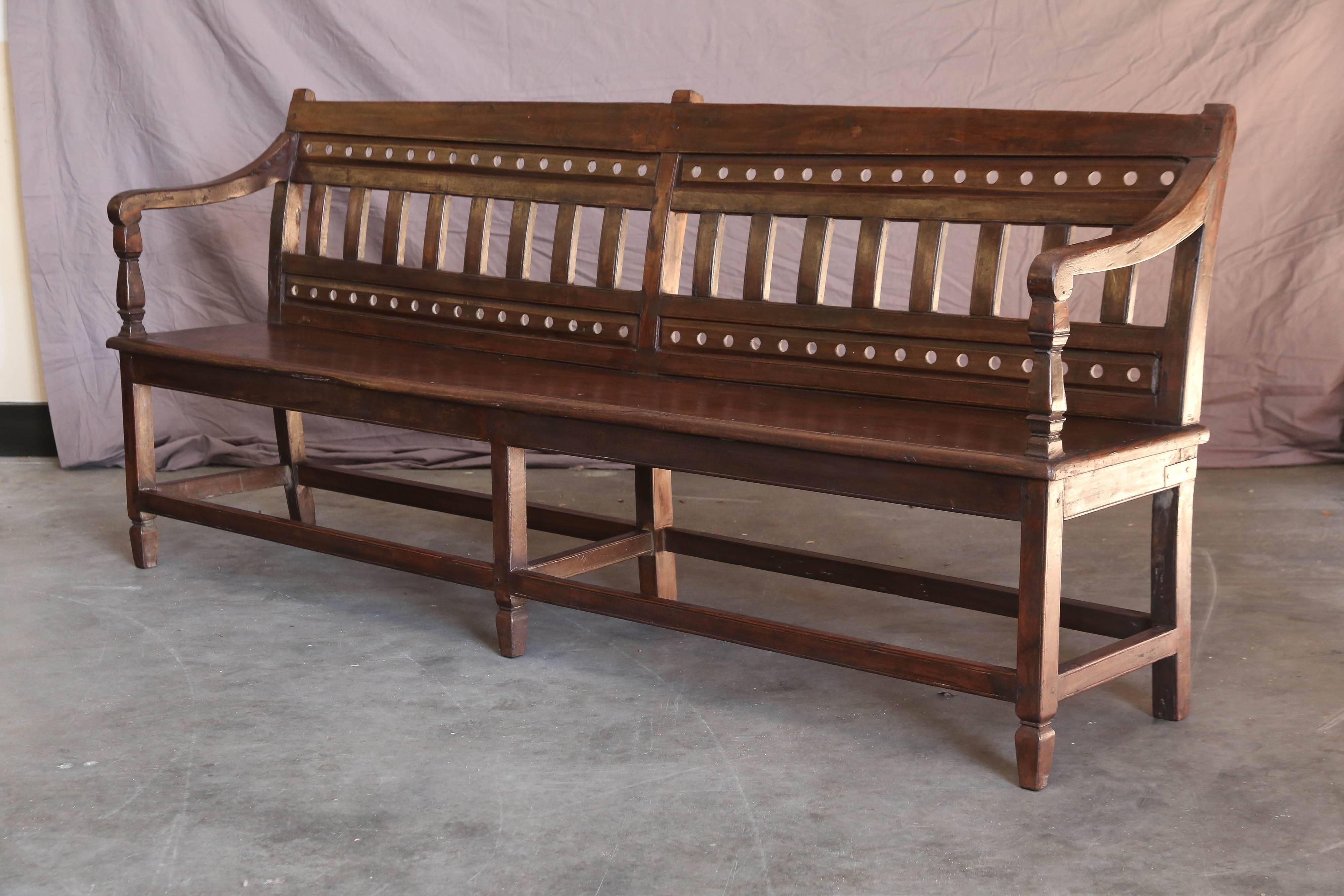 This is a magnificent solid teak wood authentic Raj bench from a British Colonial civil service office. It is 87 inches long and has six sturdy legs. Firm and elegant. Will not wobble. Represent the best in British Colonial craftsmanship. A very