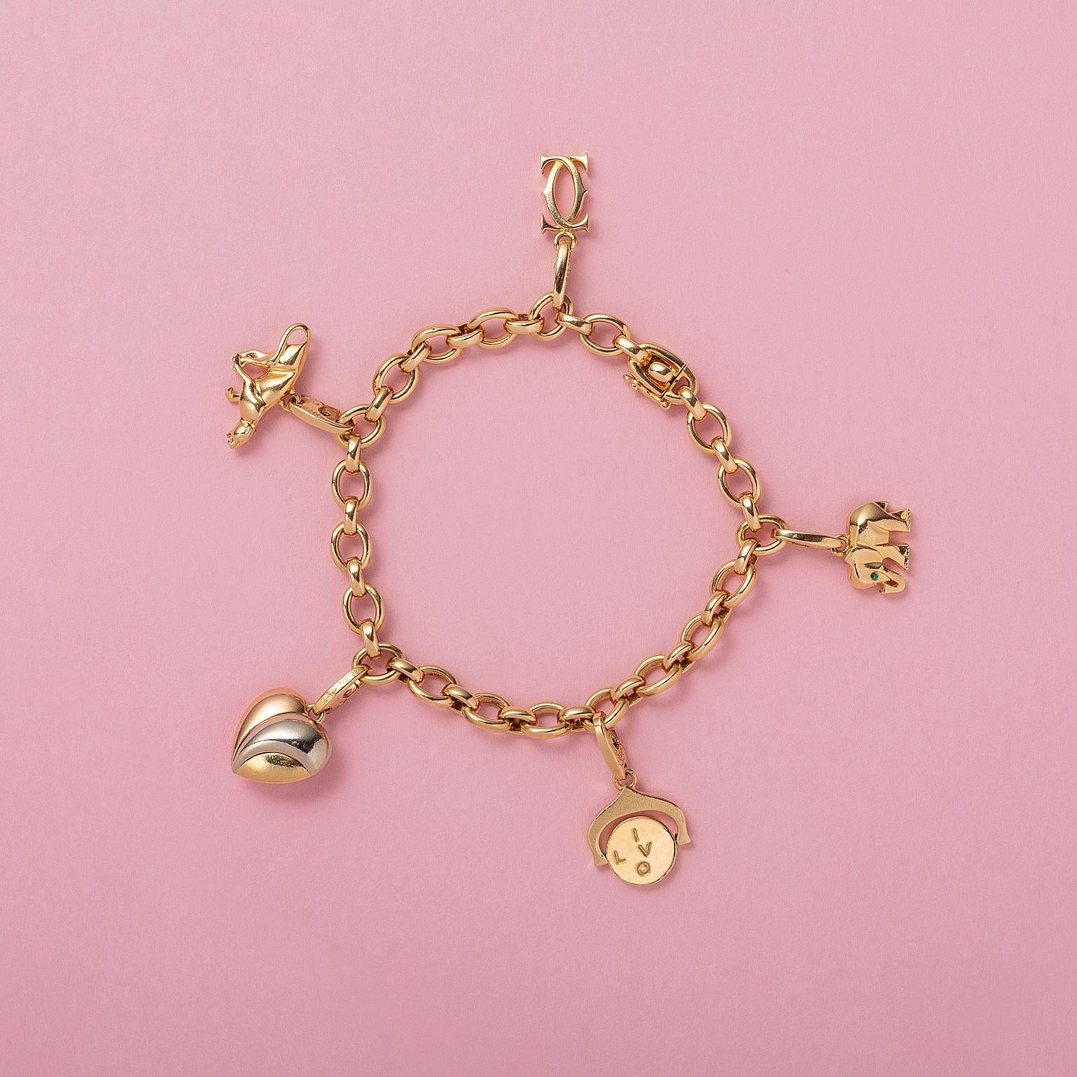 Un brazalete de oro amarillo de 18 quilates firmado y numerado: Cartier, 1995, D 39522, Francia, con 5 dijes desmontables: Doble C nº. 692348, Pantera no. 717904, Corazón de la Trinidad nº 745139, Te quiero giratorio nº 745656, Elefante. 745656,