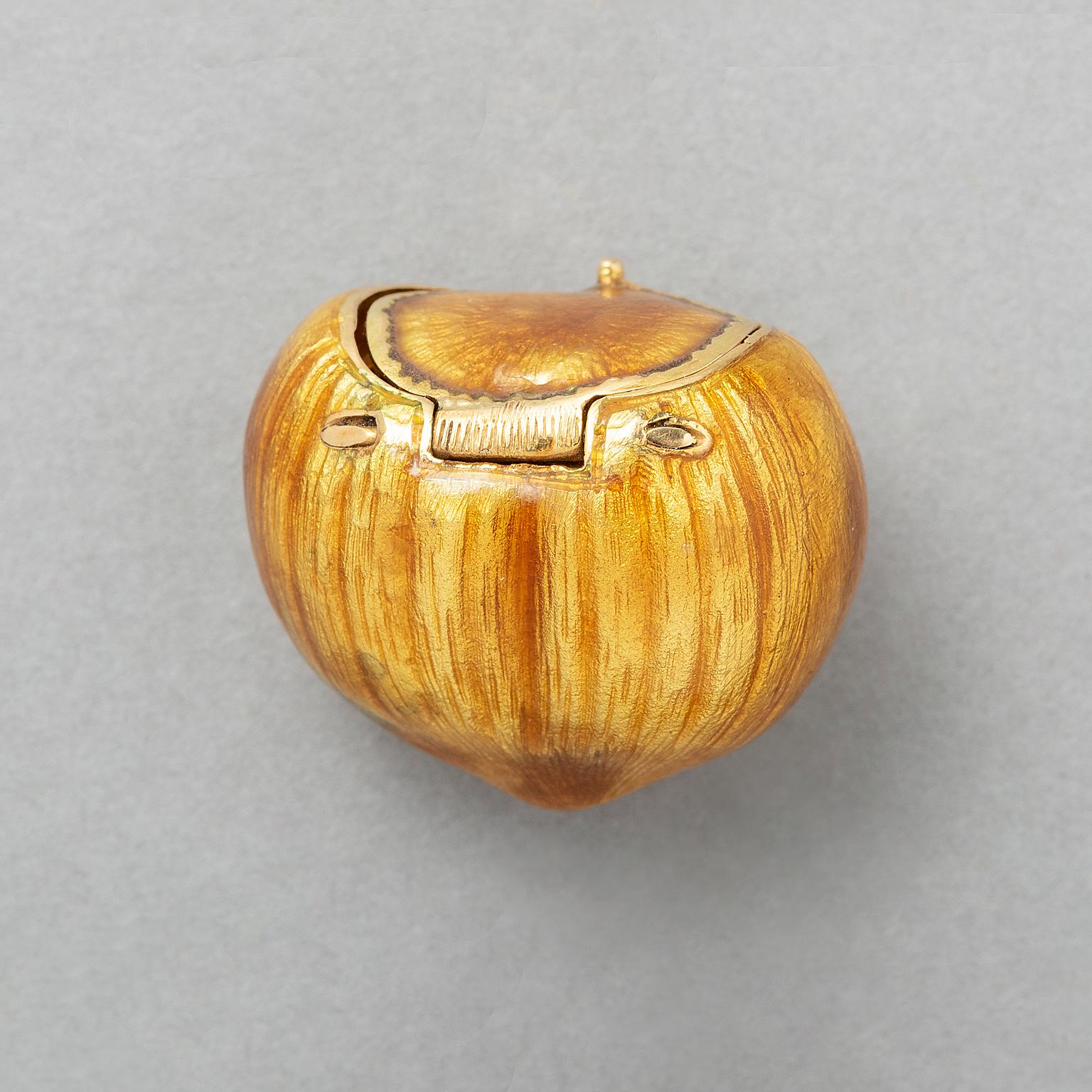 An 18-karat yellow gold pill box in the shape of a hazelnut engraved and and with brown enamel, signed: Gucci, Italy.
weight: 23.14 g 
dimensions: 2.5 x 2 cm