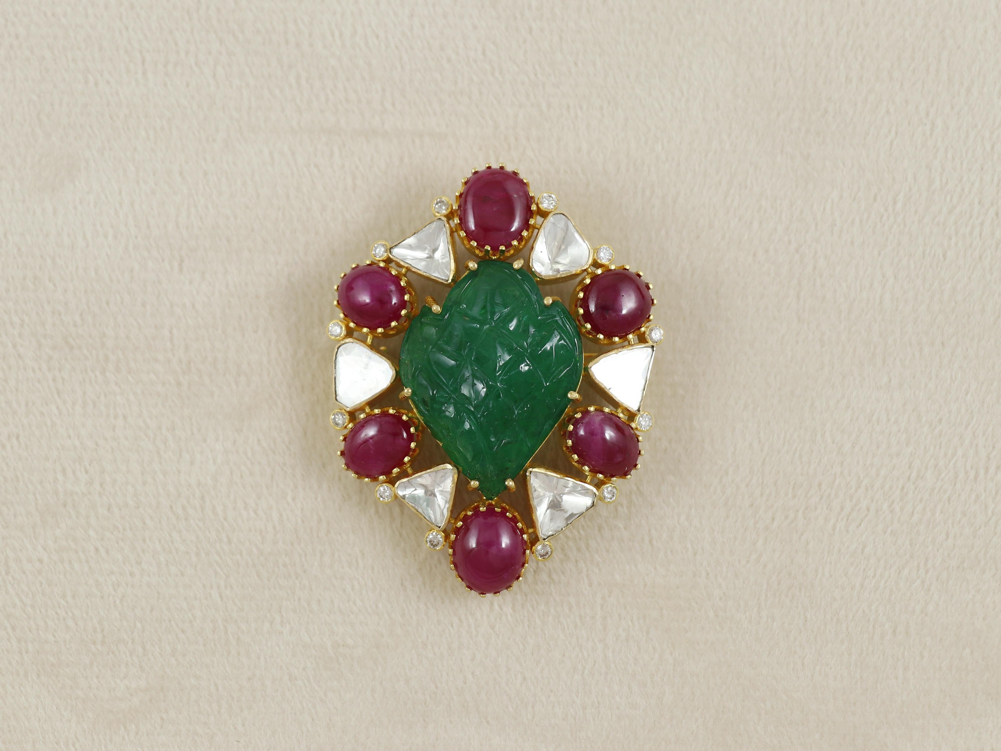 Broche/pendentif en or 18 carats avec au centre une émeraude zambienne naturelle de 32 carats en forme de bourgeon de lotus sertie dans des griffes ouvertes. 

L'émeraude est également entourée d'un rubis naturel de Birmanie et de polkis de diamants