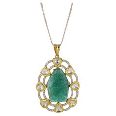 An 18K gold emerald carving pendant set with natural full cut and uncut diamonds