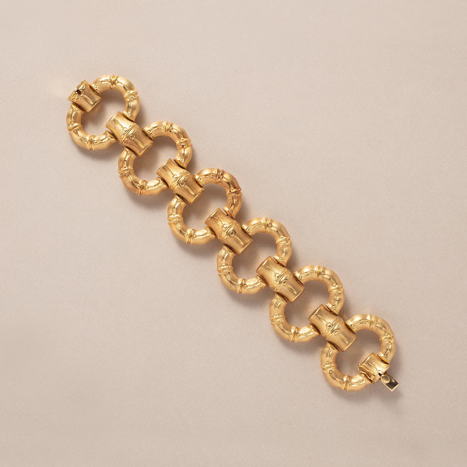 An 18-karat gold bracelet with large oval links engraved with bamboo motifs on one side matted and a the other side polished, Italy, circa 1970.

weight: 66.1 g
length: 21 cm
dimensions link: 4.2 x 3 cm