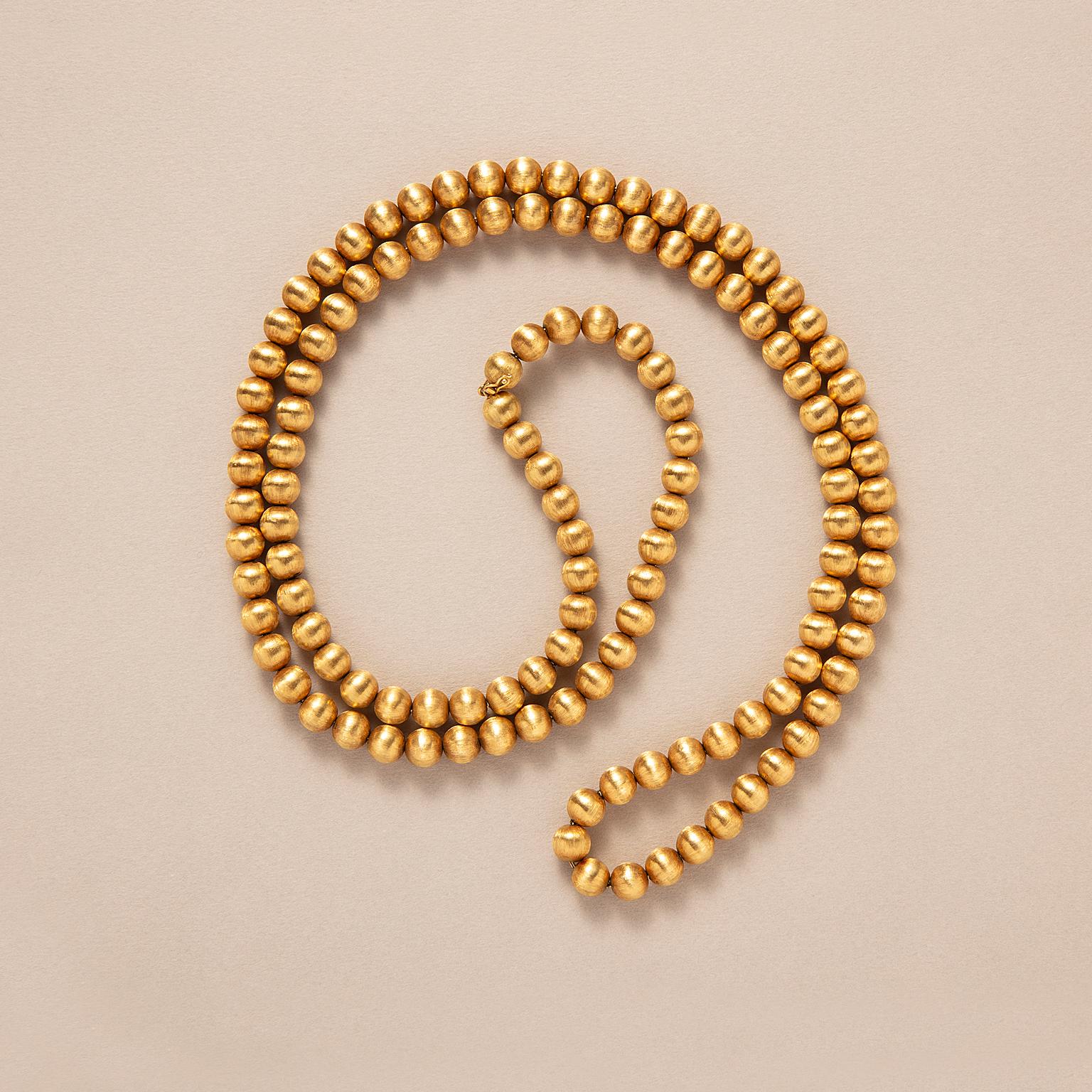 Collar largo de oro de 18 quilates con bolas satinadas, Italia, hacia 1960.

peso: 110,17 g
longitud: 99 cm 
anchura: 7,7 mm