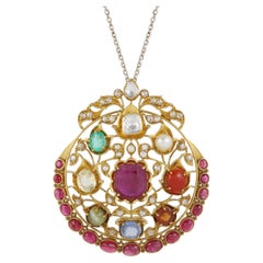 An 18K gold Navratna pendant set with nine natural gemstones with diamond