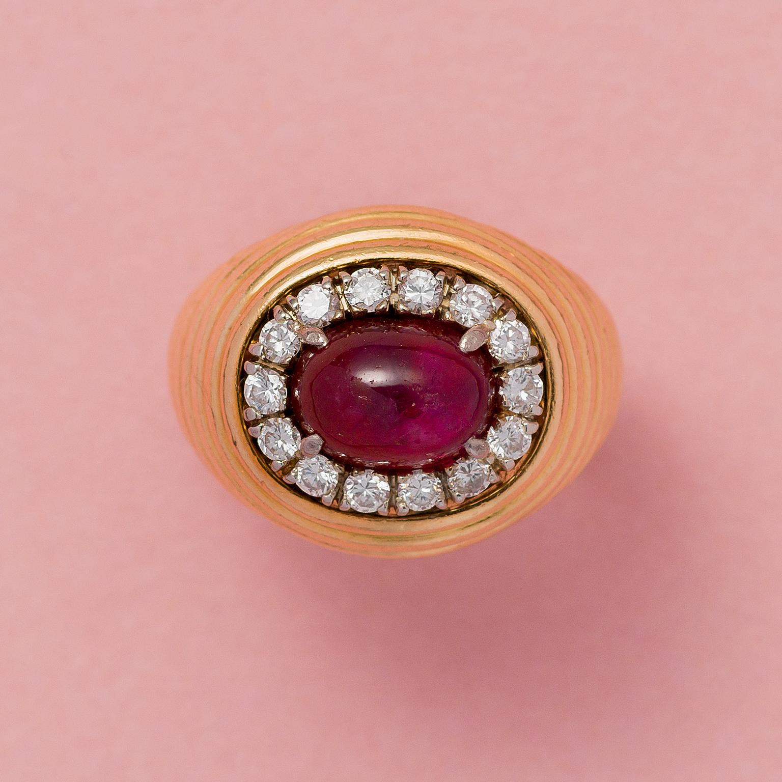 An 18 carat gold ribbed gold pinky ring set with a juicy unheated Burma ruby (app. 3.25 carat) the oval cabochon cut stone is surrounded by brilliant cut diamonds, Austrian circa 1960.

weight: 14.5 grams
ring size: 15.5 mm. / 5 US