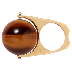 Un anello a trottola in oro 18k con una sfera di occhio di tigre