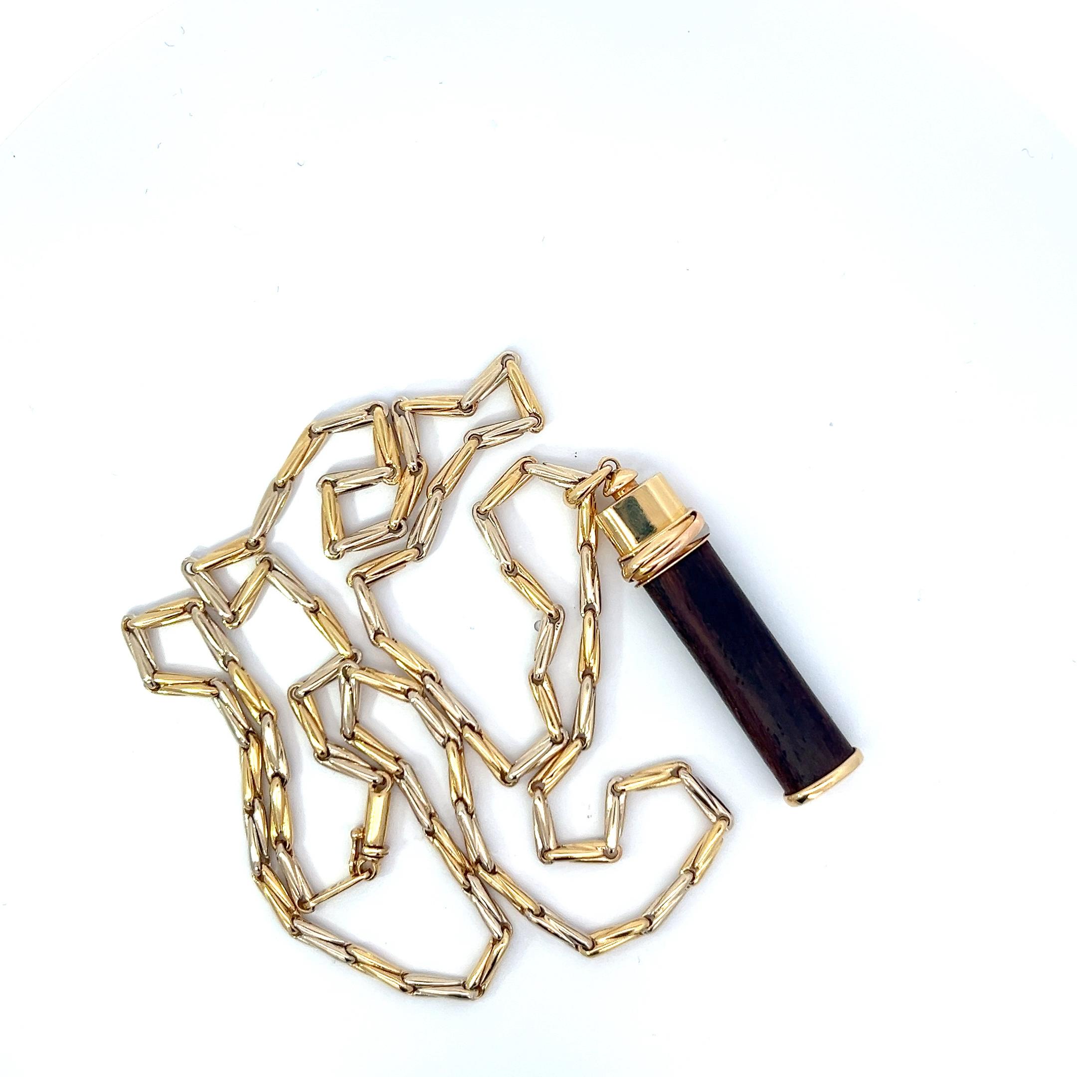 
Une chaîne en or jaune et blanc 18 carats et une chaîne en or jaune et bois 18 carats. 
pendentif de Cartier.
		
Origine : Italie.
Age : Circa 1990.
Dimensions : La chaîne mesure environ 70 cm de long et le pendentif environ 6 cm de long.
Poids :