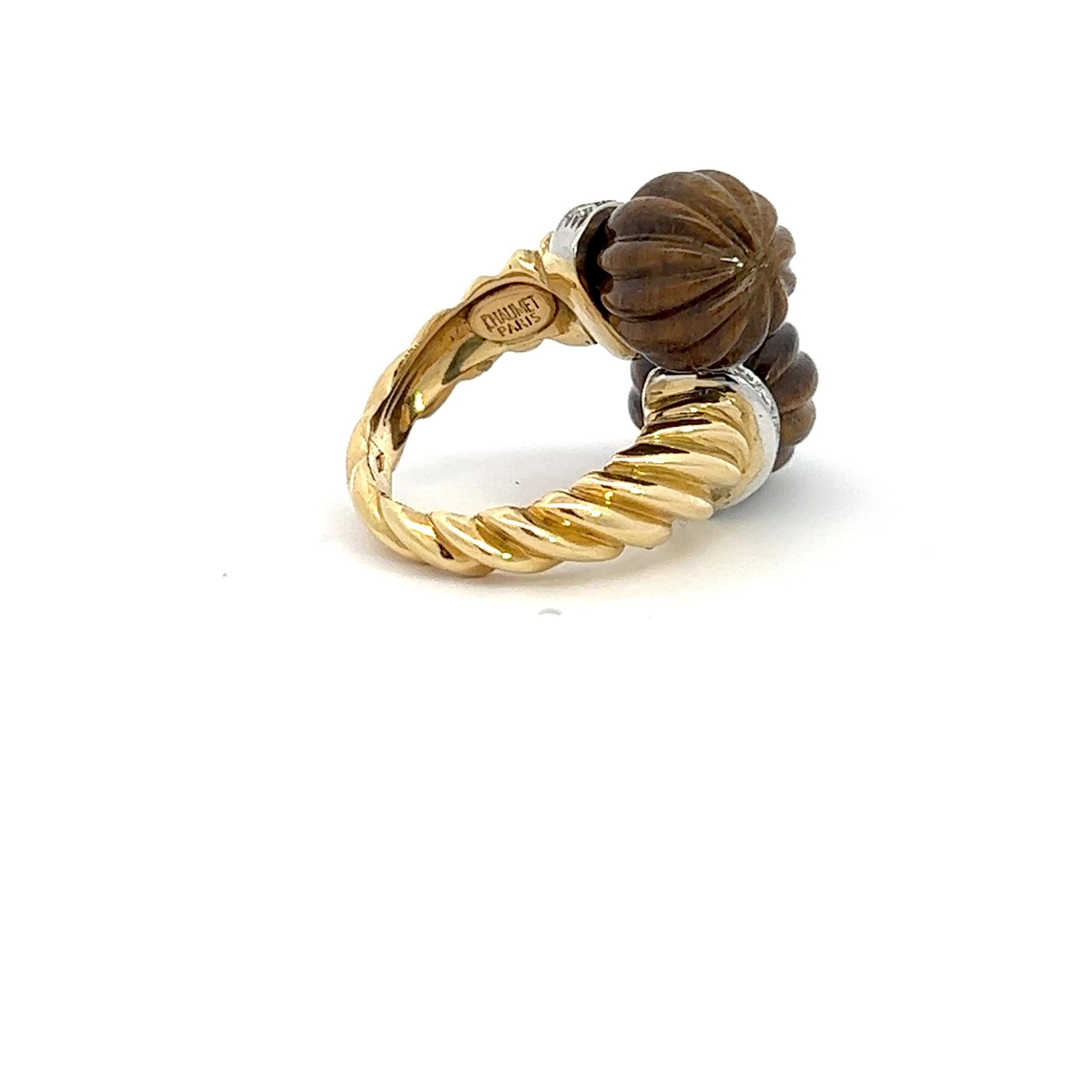 An 18k yellow gold ring by Chaumet.
The ring is decorated with 2 carved pieces of Tiger's Eye Quartz and circa 0.6ct. Diamonds.
Size 57, ring can be resized by a good goldsmith.
Made in France, circa 1970.

Marked with the French hallmark for 18k