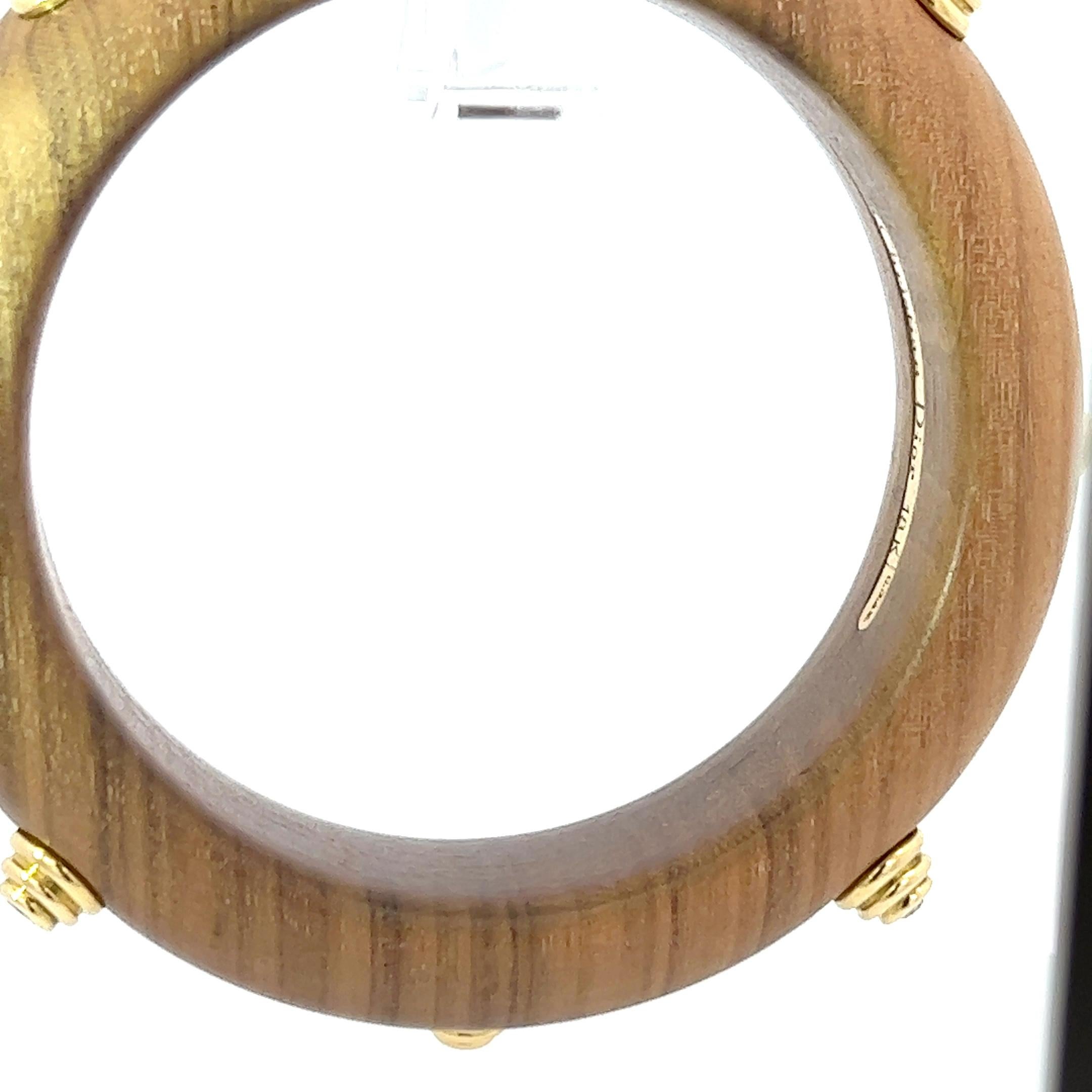 A very rare 18k yellow gold, wood and diamond bangle by Christian Dior.
Probably from the 1970s.
Total diamond weight: circa 0.8ct.

The bangle is signed Christian Dior and marked with the makers mark. Stamped with 18k.

Please note that this
