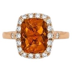 An 18kt rosé gold natural Fire Opal and Brilliant cut diamond halo ring