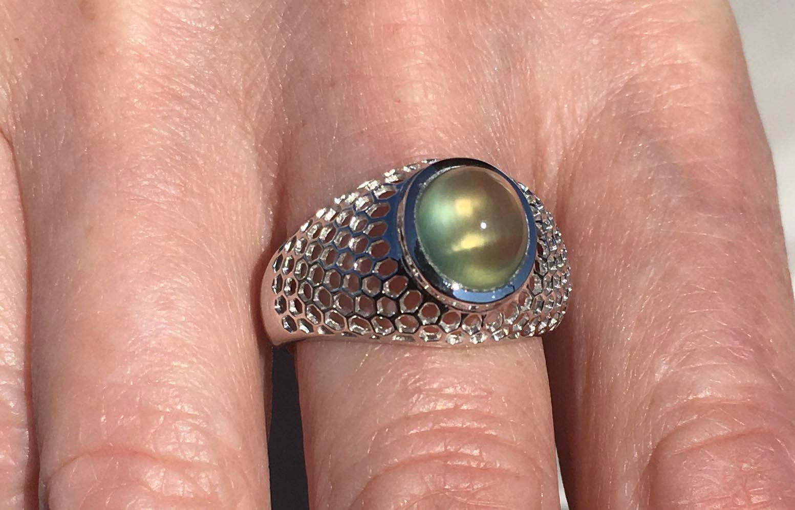 A Kary Adam Designed, 18kt White Gold Ring set with a Zambian Prehnite Oval Cabochon. Prehnite weight is 2.33 Carats, 18kt Gold weight is 5.1 Grams. Ring size is 8 USA

Originally from San Diego, California, Kary Adam lived in the “Gem Capital of