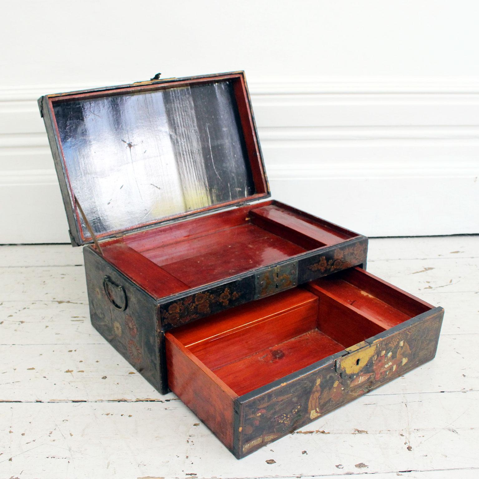 This beautiful chinoiserie box is in incredible original condition. It is decorated on all sides with chinoiserie gilt decoration and has carrying handles. The interior, which has several compartments, is dark red lacquer. At the back of the