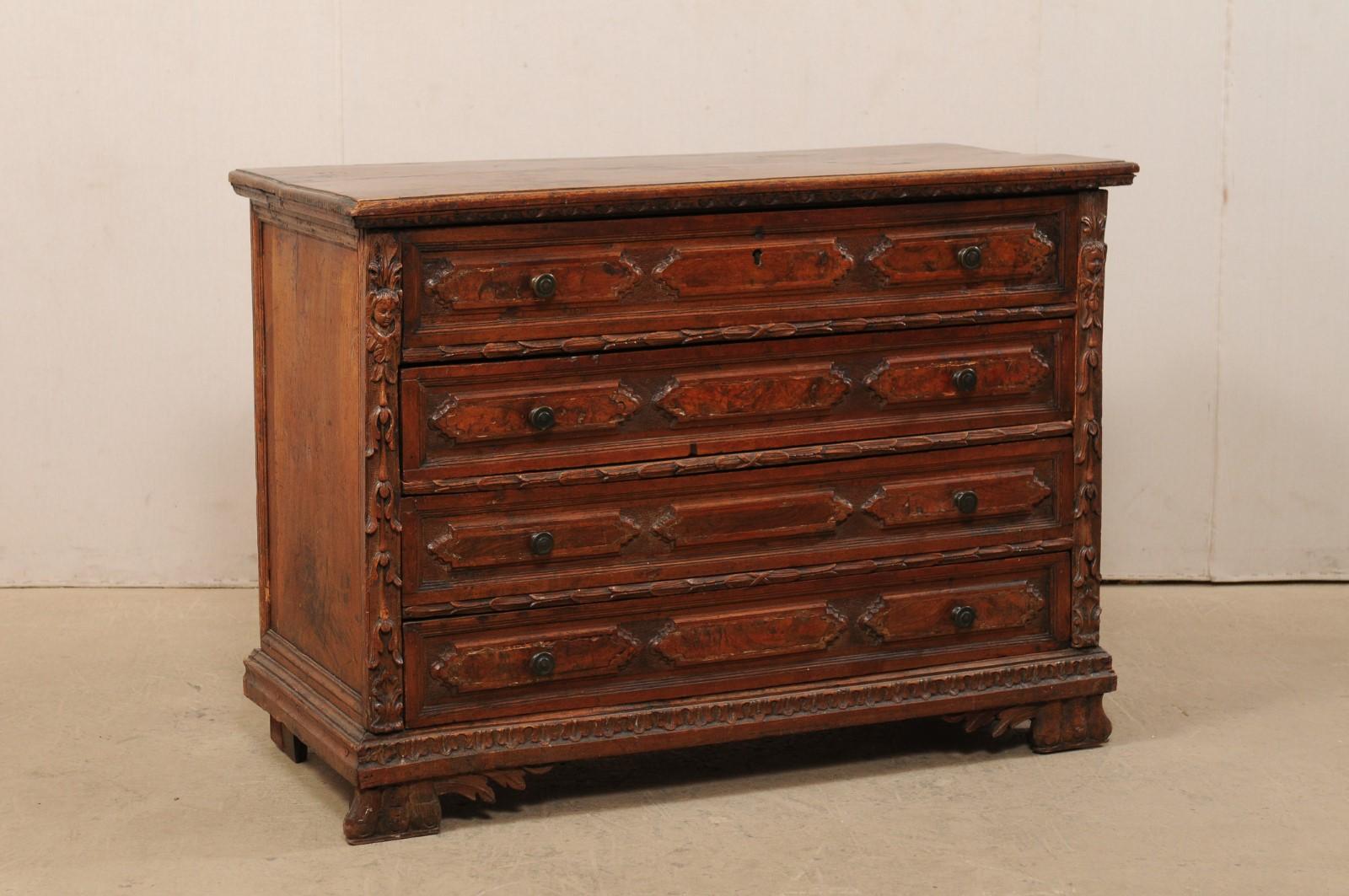 A stately Italian four-drawer carved wood chest with putto and foliage accents from the 18th century. This antique commode from Italy features a pair of side posts which are beautifully carved with a putto and leaf motif, which flank the four