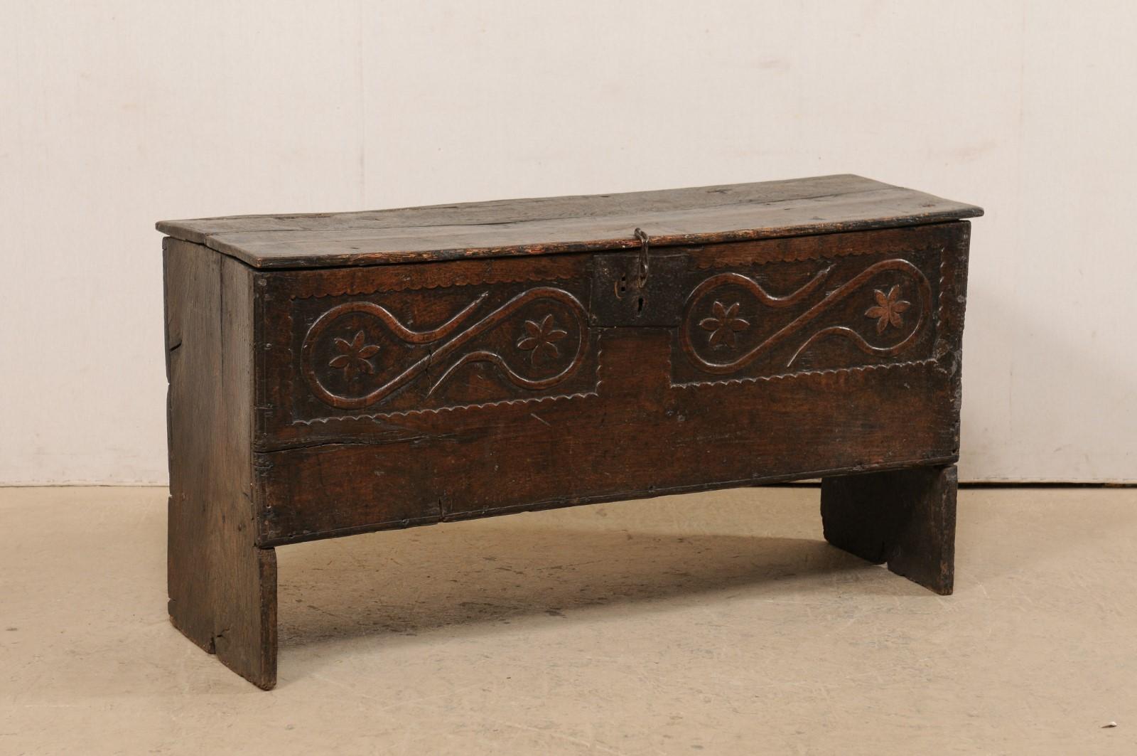 An Italian larger-sized carved wood cassone (trunk), with it's original iron hardware, from the 18th century. This antique chest from Italy is exquisitely rustic, with front which has been whimsically, hand-carved with two raised panels with