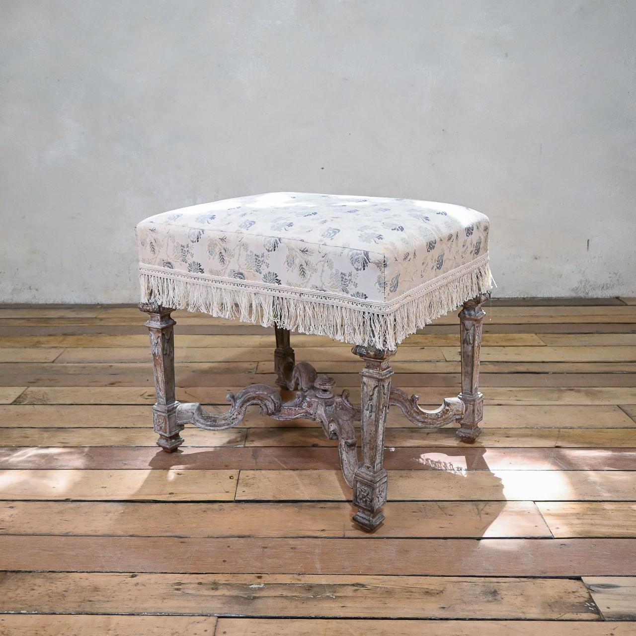 A charming 18th-century and later French Louis XIV dressing stool. Raised on four carved legs, united by a central-shaped stretcher. Displaying a whitewashed based, 18th century and later elements. Upholstered in a faded period silk, demonstrating
