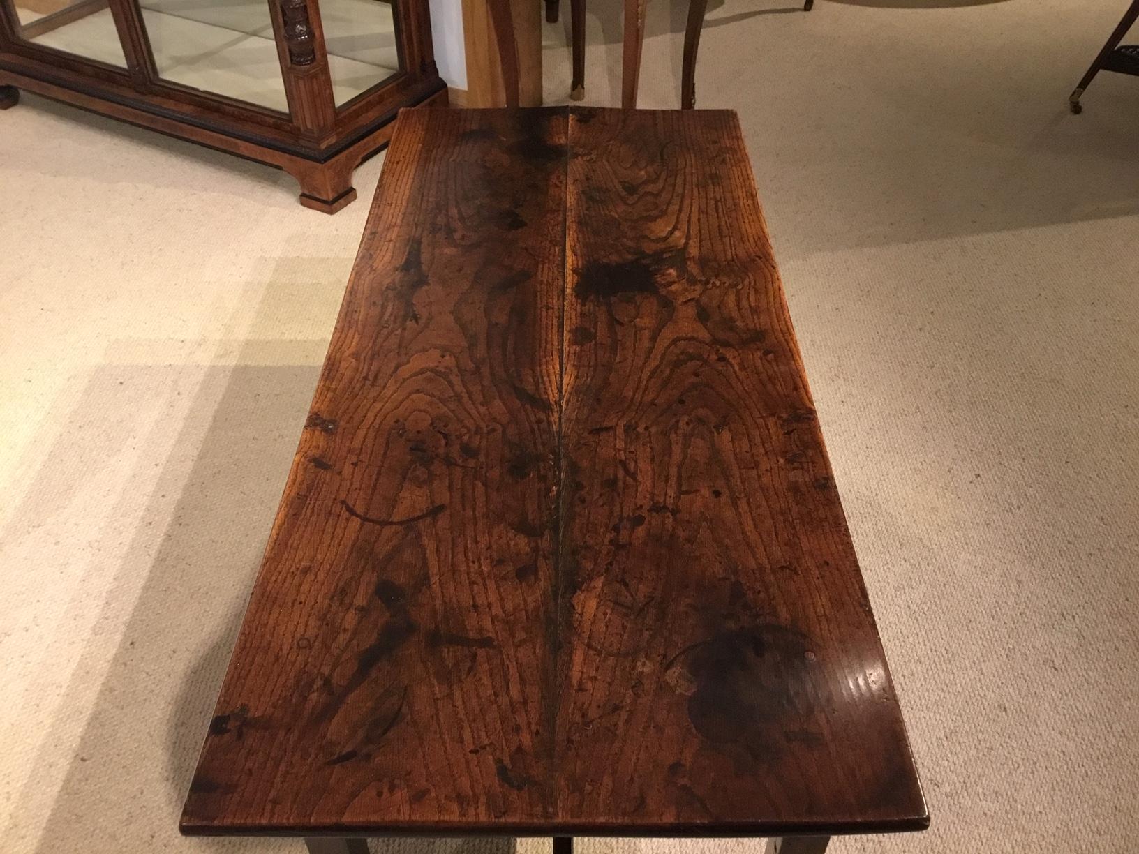 An 18th century antique elm coffee table. Having a rectangular two plank elm top of wonderful colour and patination, with an elm frieze and square supports, united by an H stretcher. English circa 1780-1800

Condition: This table is in superb
